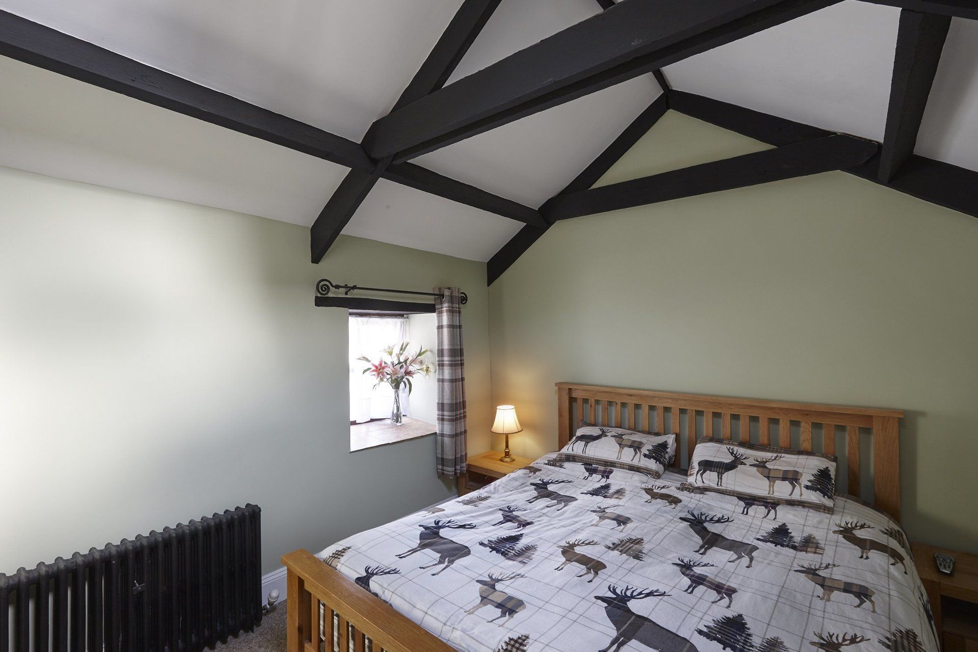 A bedroom with a king size bed and a window