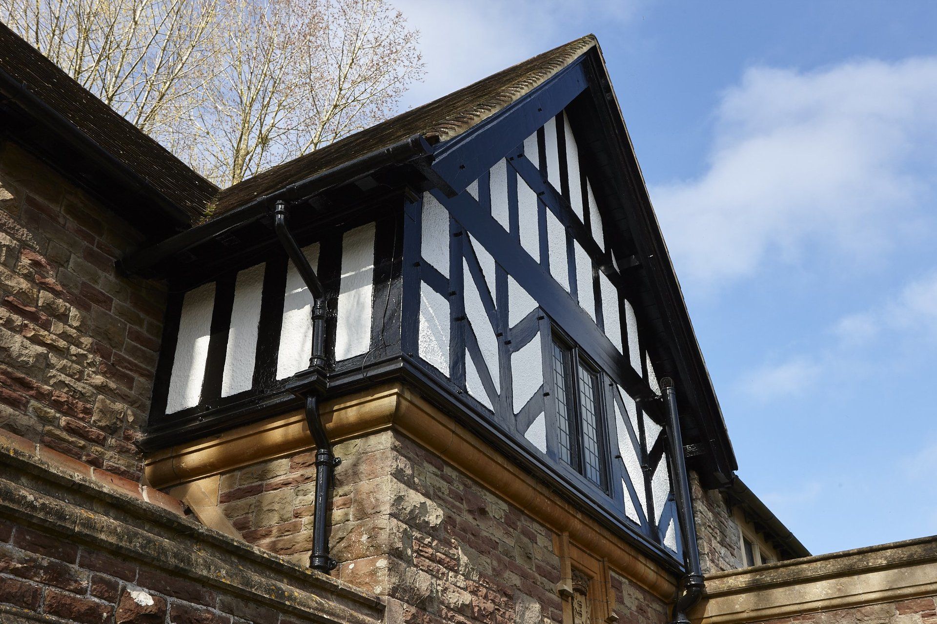 A brick building with a black and white trim on the roof
