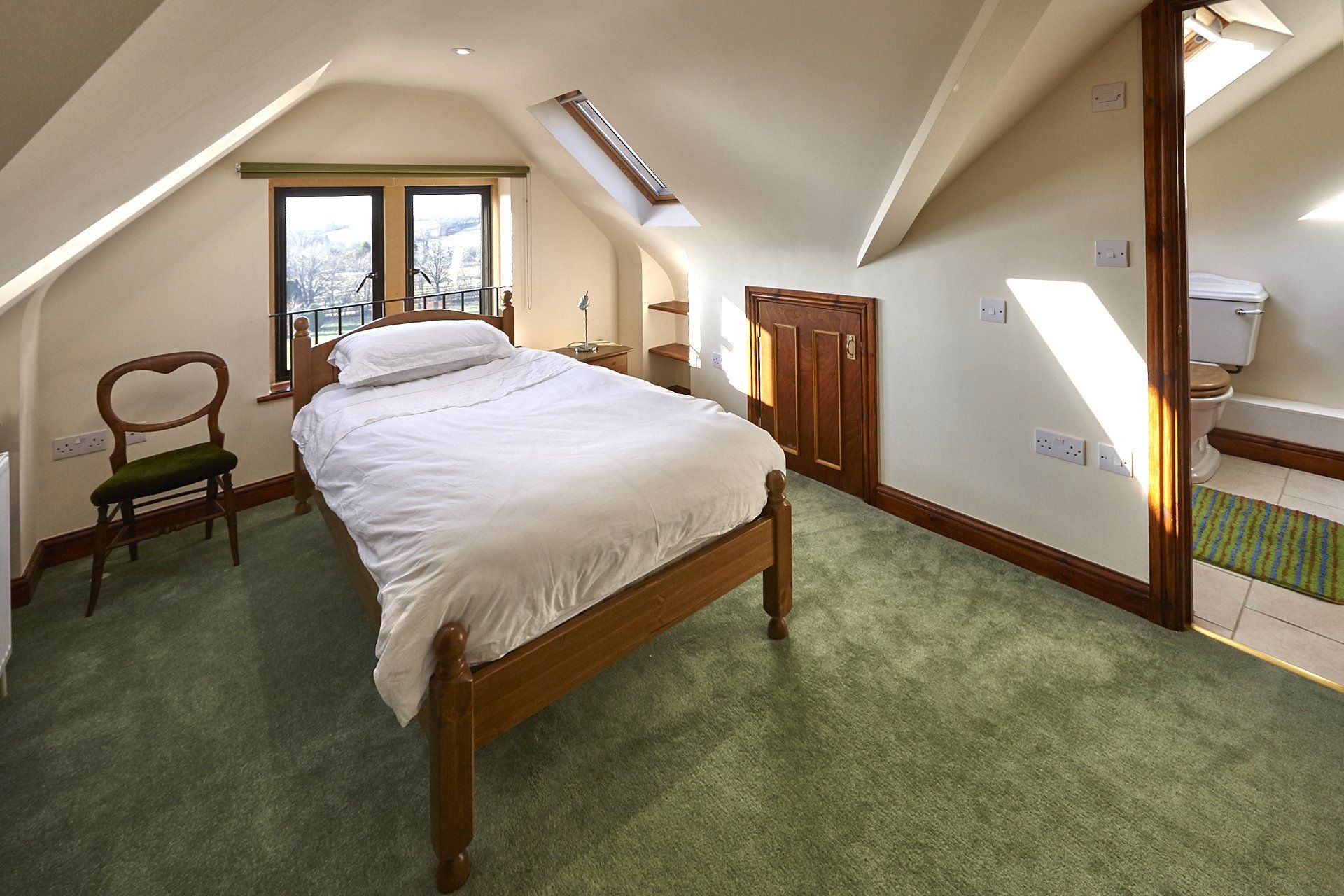 A bedroom with a bed and a chair in it