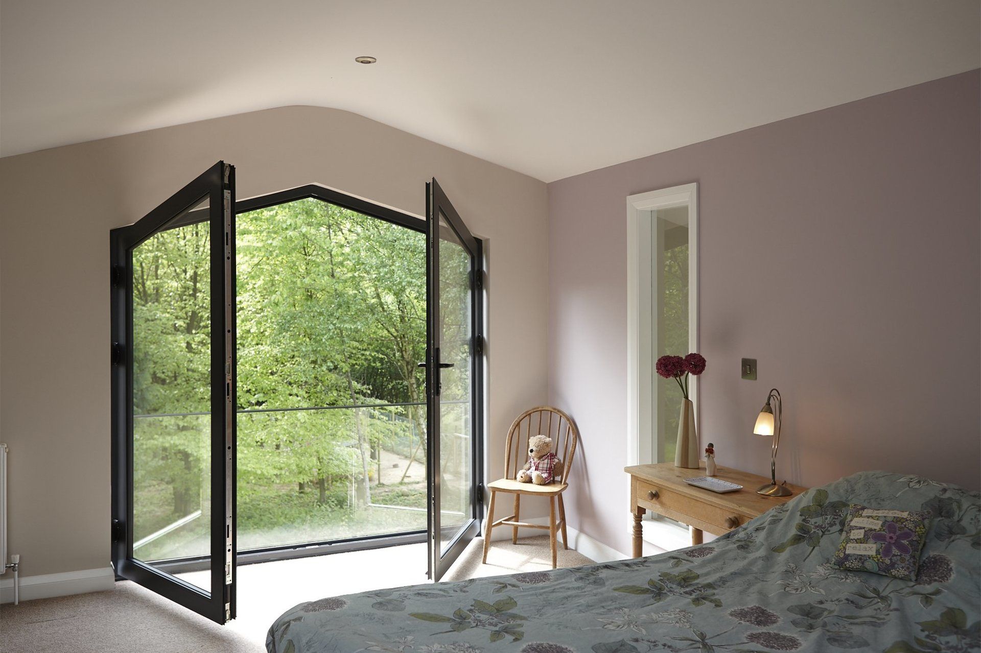 A bedroom with a bed , desk , chair and sliding glass doors