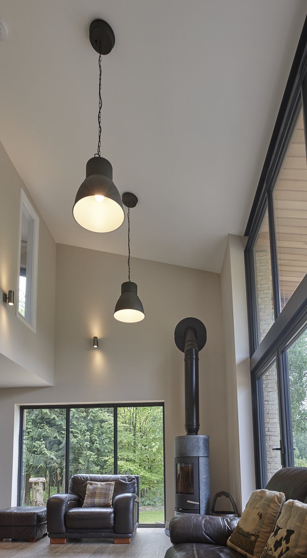 A living room with a couch , chair , fireplace and sliding glass doors.