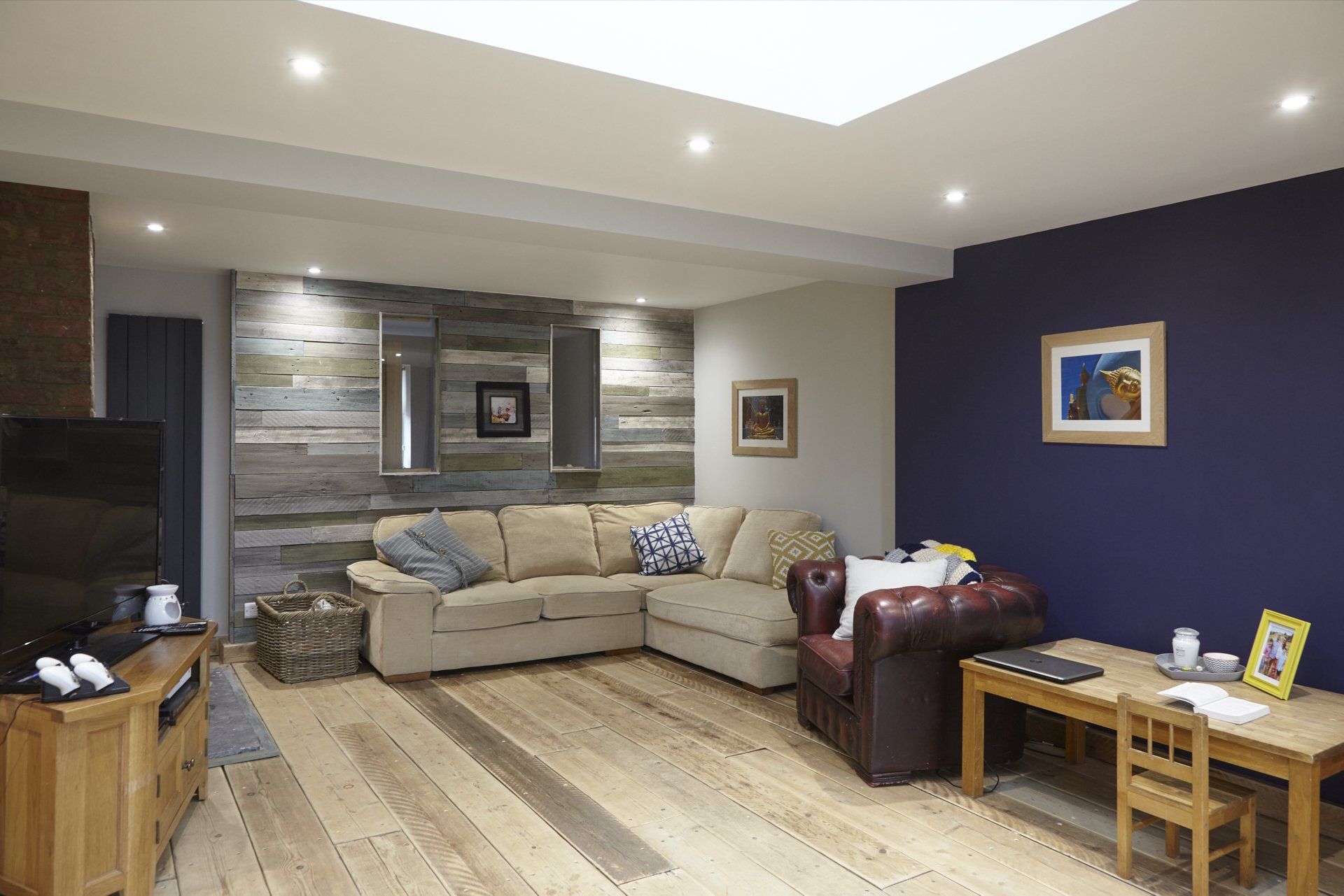 A living room with a couch , chair , table and television.