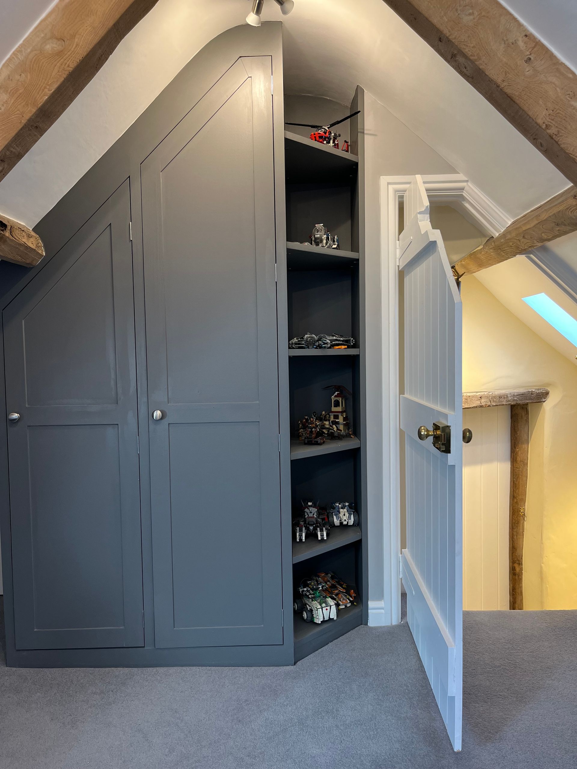 A closet with a door open and shelves filled with toys