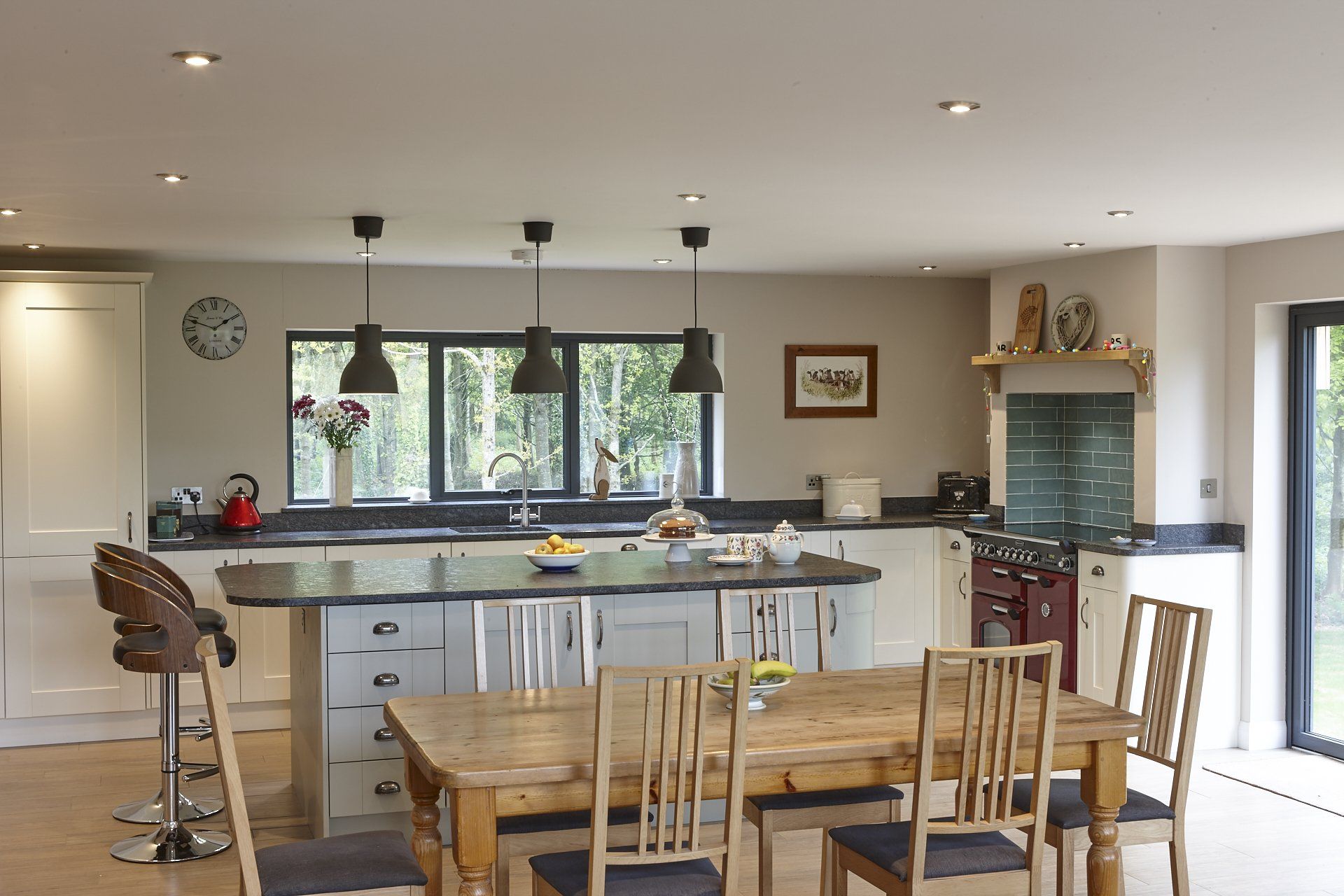 A kitchen with a table and chairs and a clock on the wall