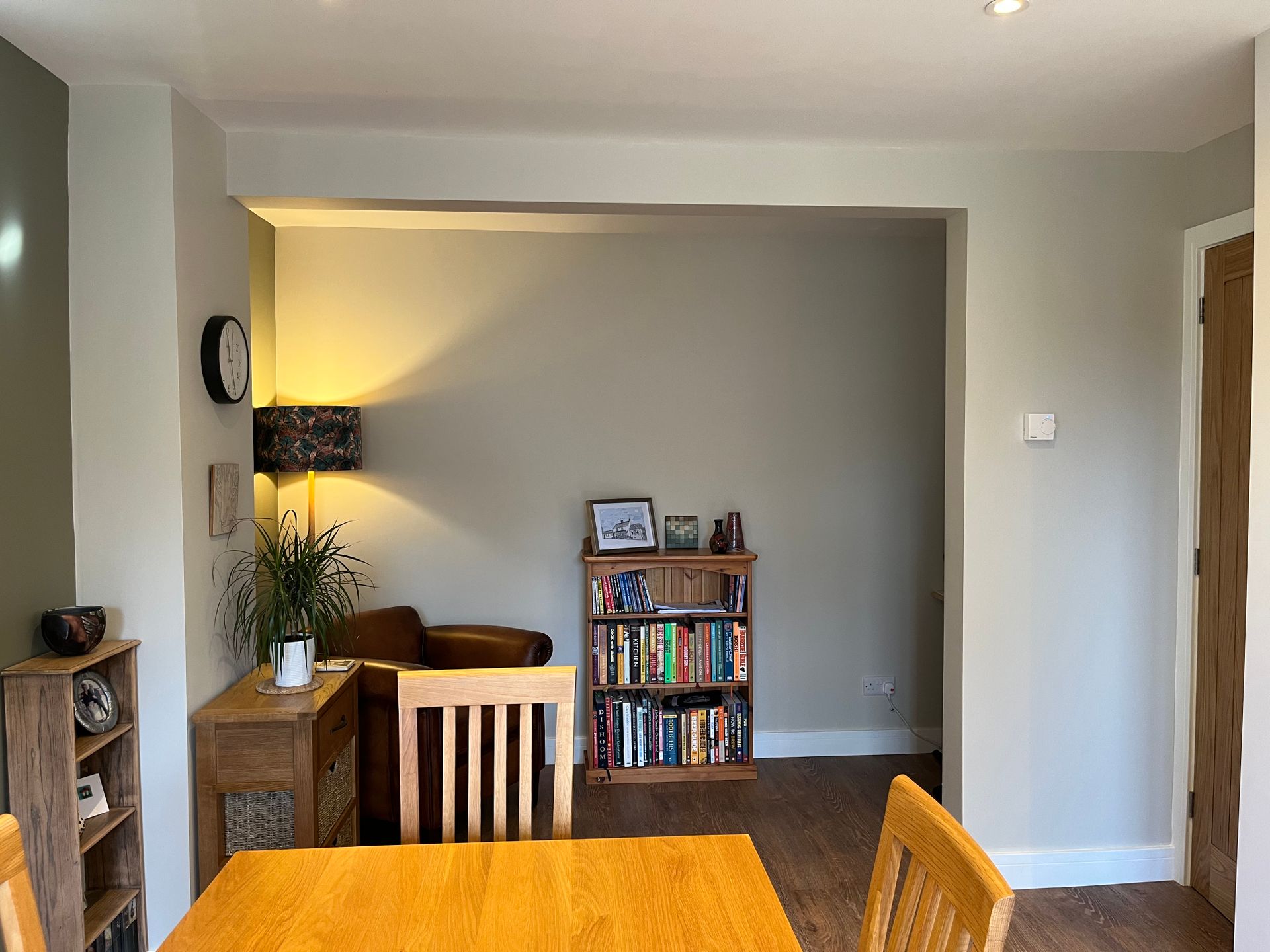 A living room with a table and chairs and a bookshelf with books on it.