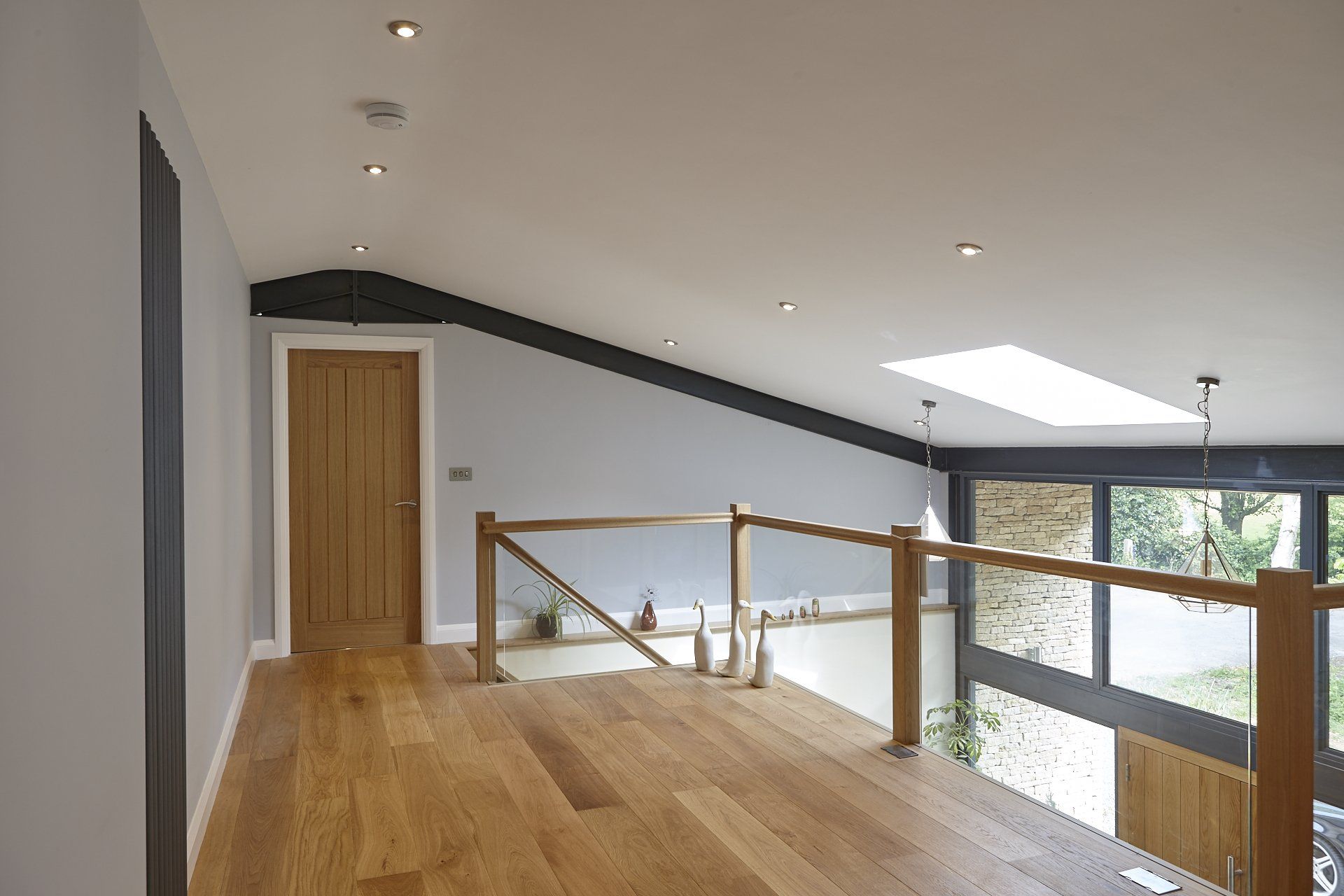 A hallway with hardwood floors and a wooden railing