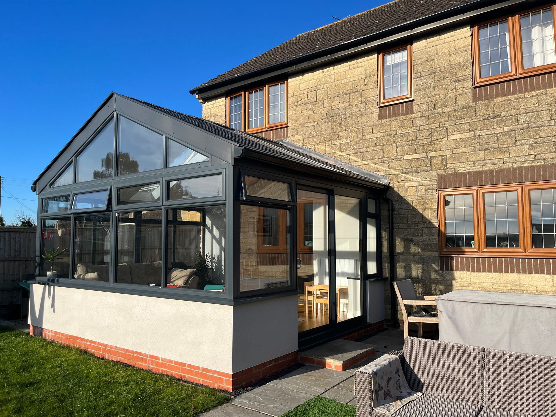 A house with a conservatory on the side of it.