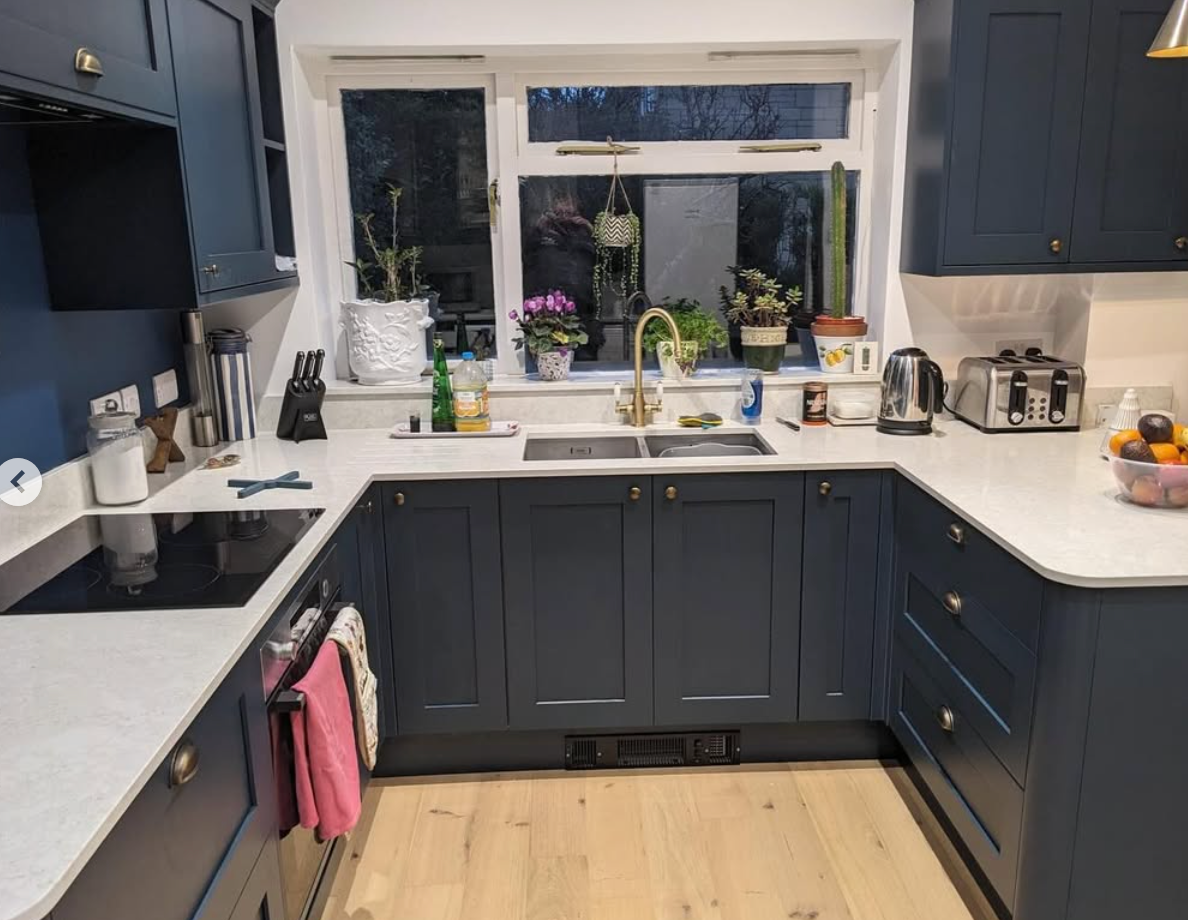 A kitchen with blue cabinets and white counter tops
