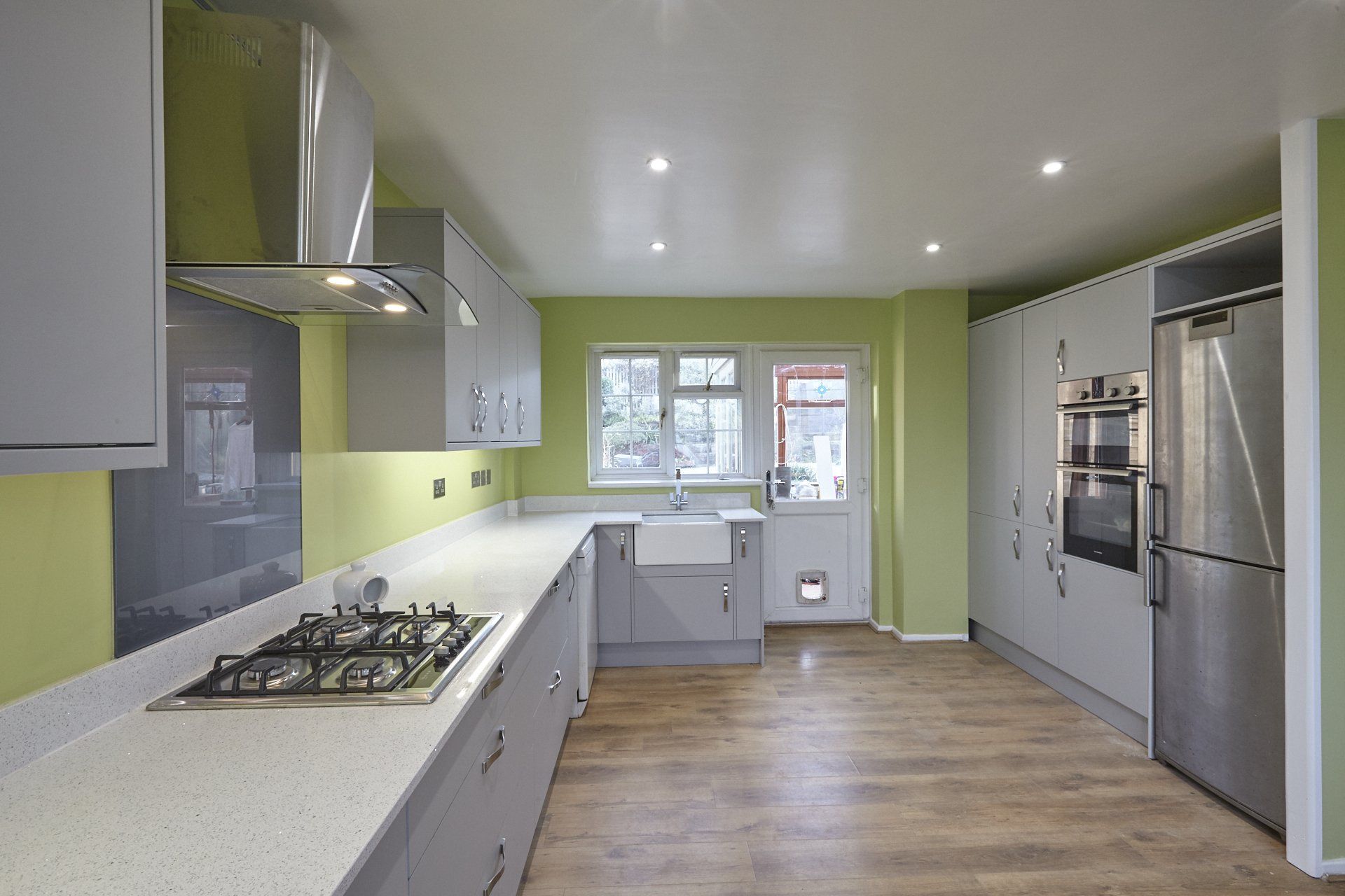 A kitchen with a stove top oven and a refrigerator.