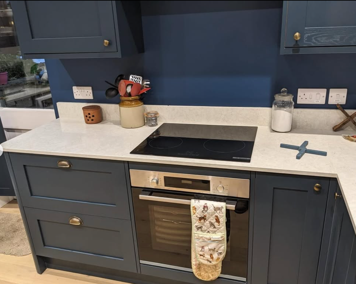 A kitchen with blue cabinets and a stove top oven