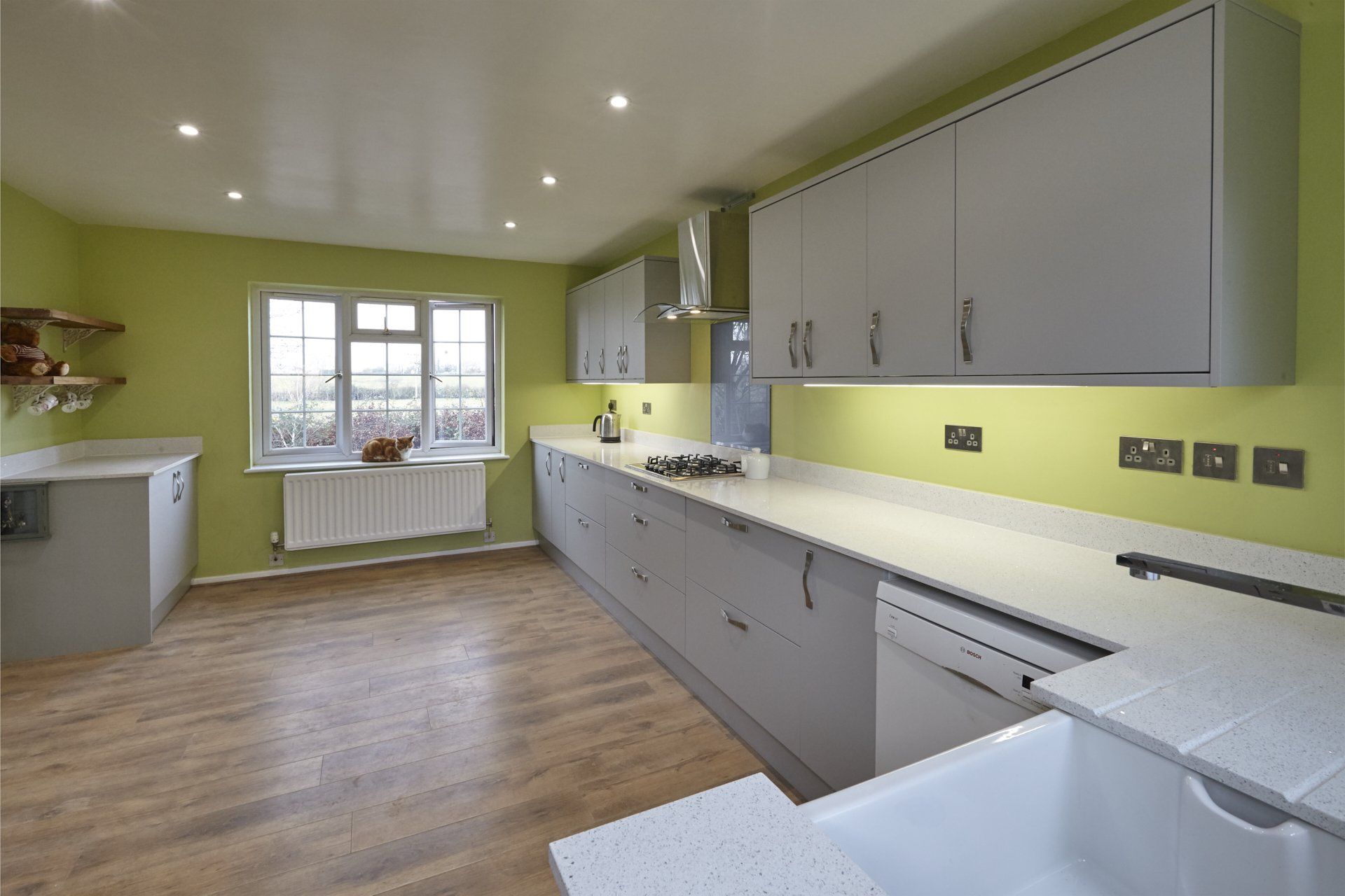 A kitchen with green walls and white cabinets