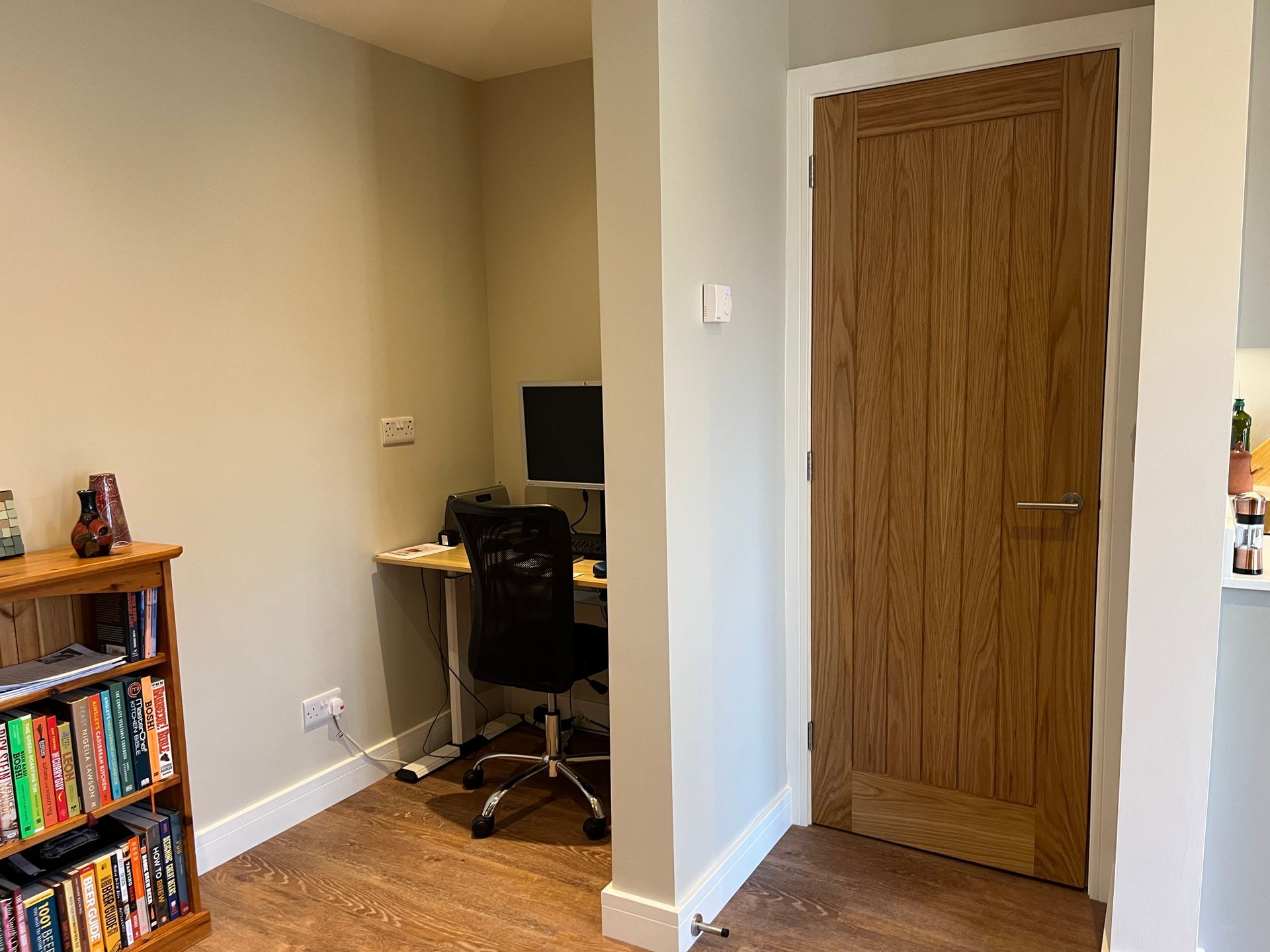 A room with a desk , chair , computer and bookshelf.
