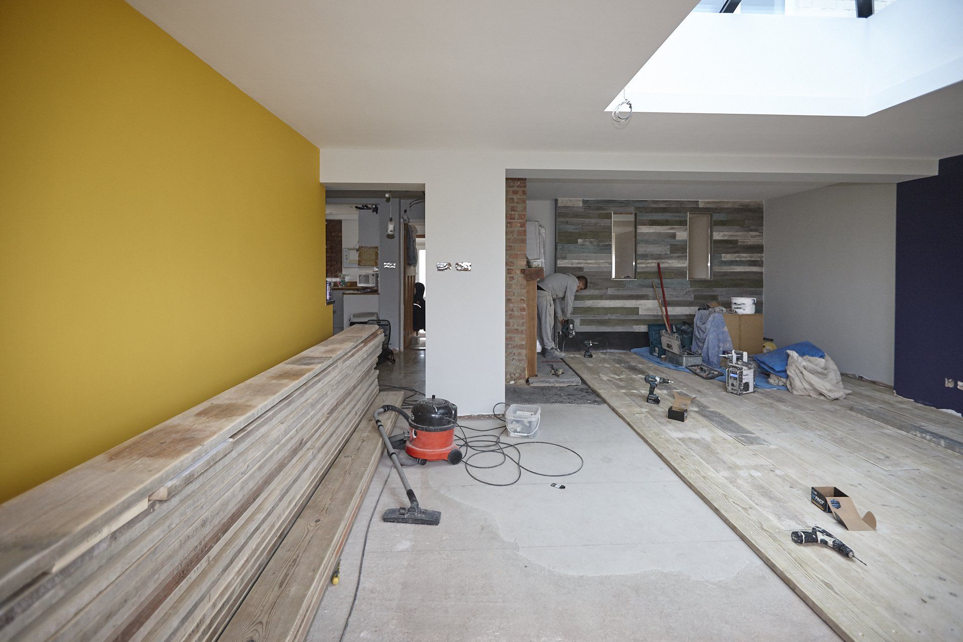 A room that is being remodeled with a vacuum cleaner on the floor.