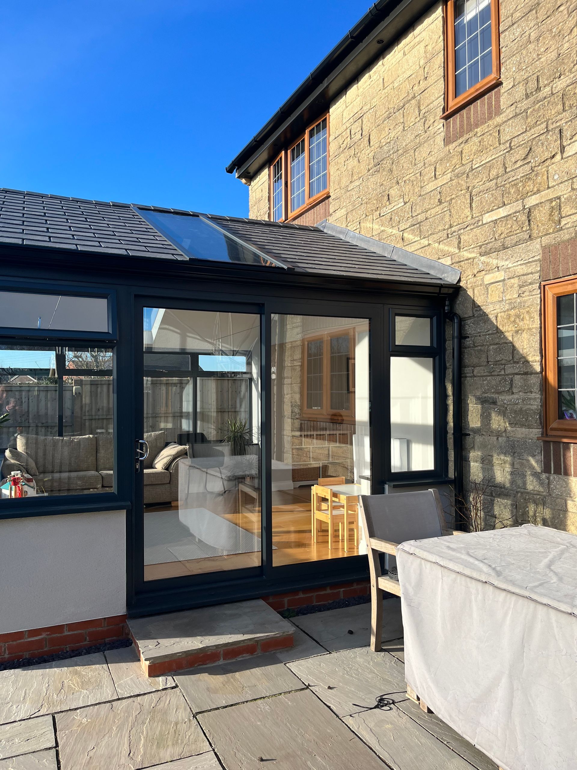 A house with a conservatory and a patio in front of it