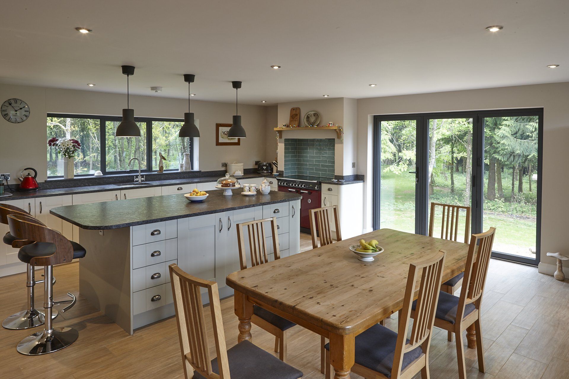 A kitchen with a wooden table and chairs and a large island.