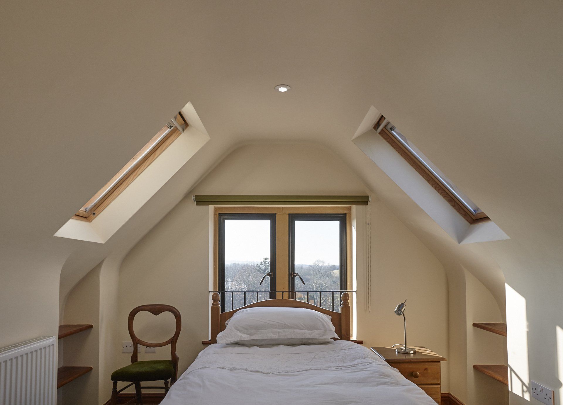 A bedroom with a bed and a chair in it