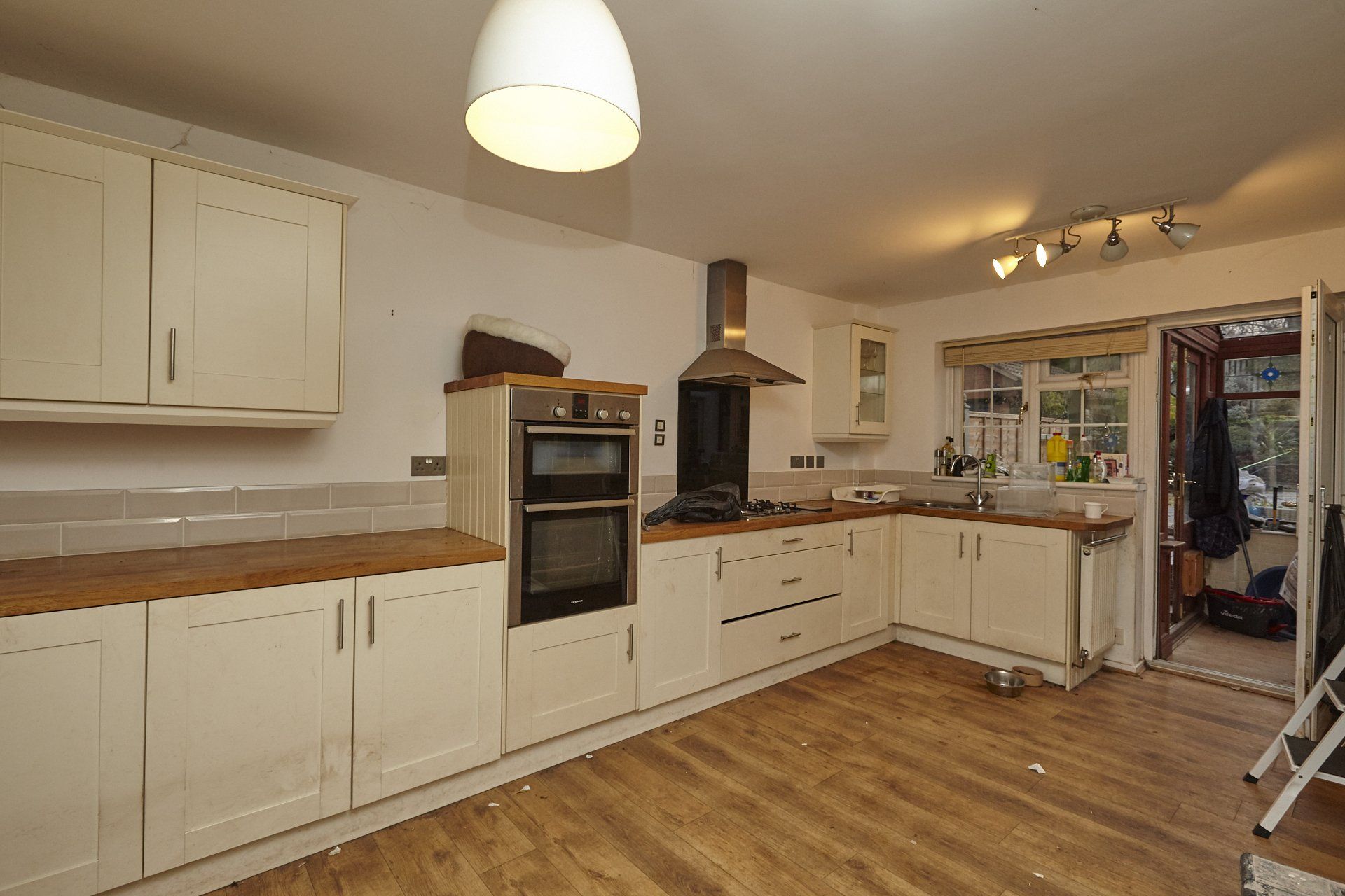 A kitchen with white cabinets and wooden floors