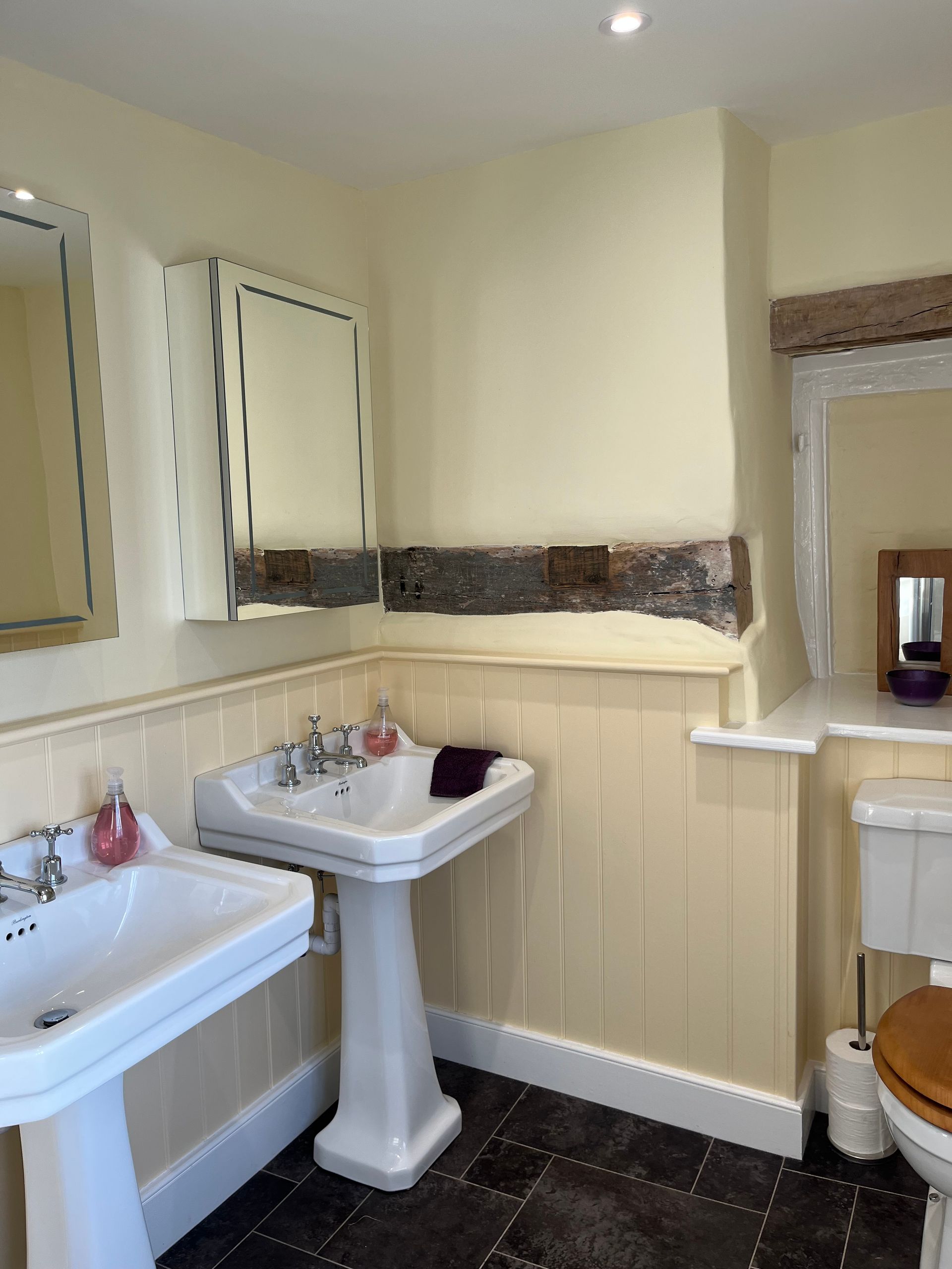 A bathroom with two sinks and a toilet