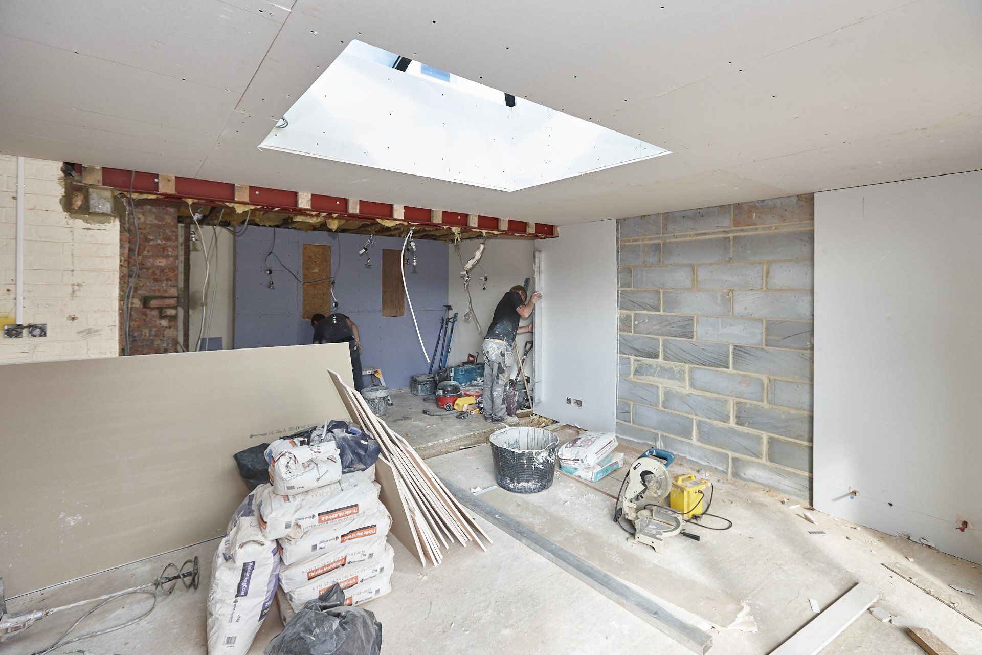 A room under construction with a skylight in the ceiling