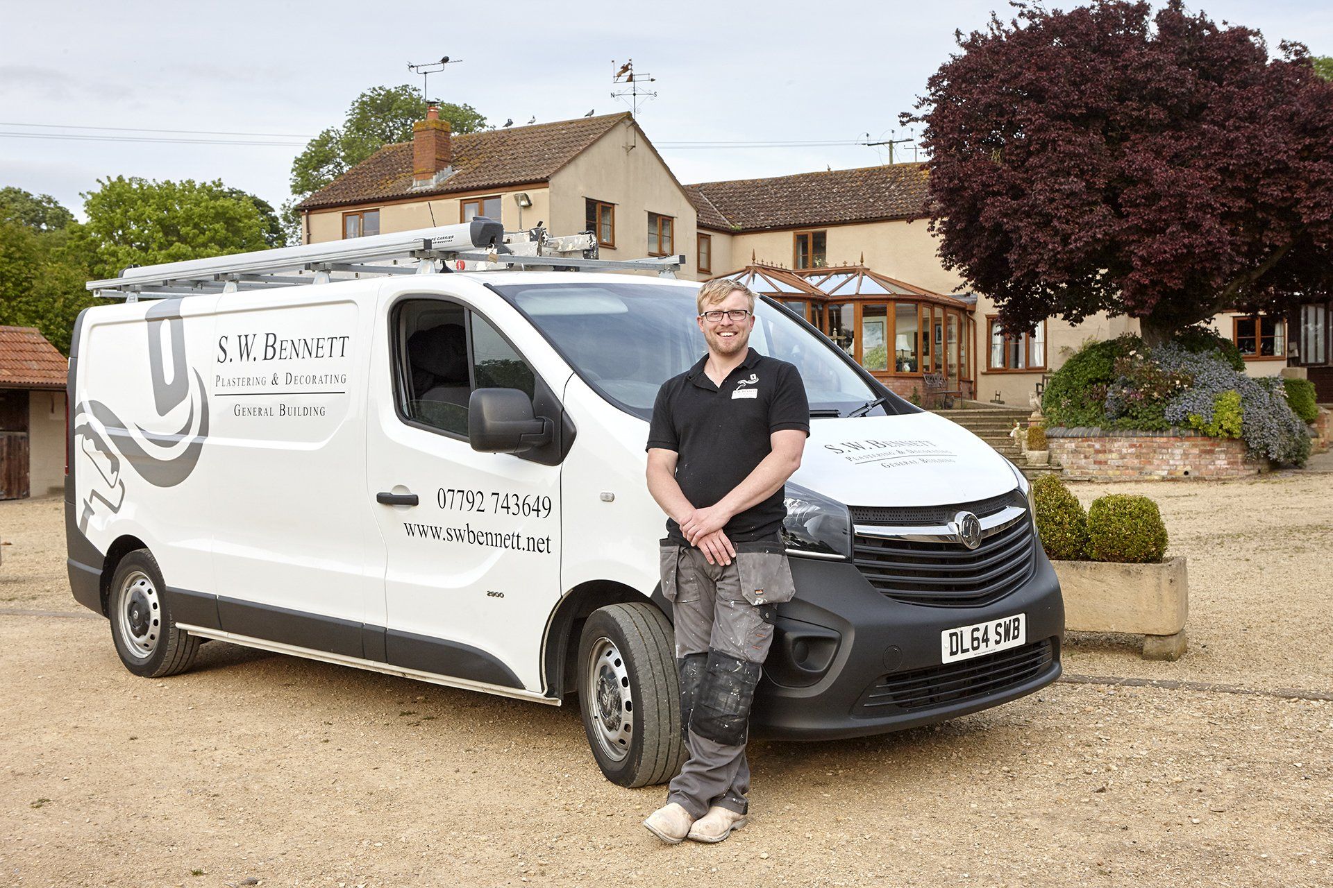 A man is standing in front of a white van.