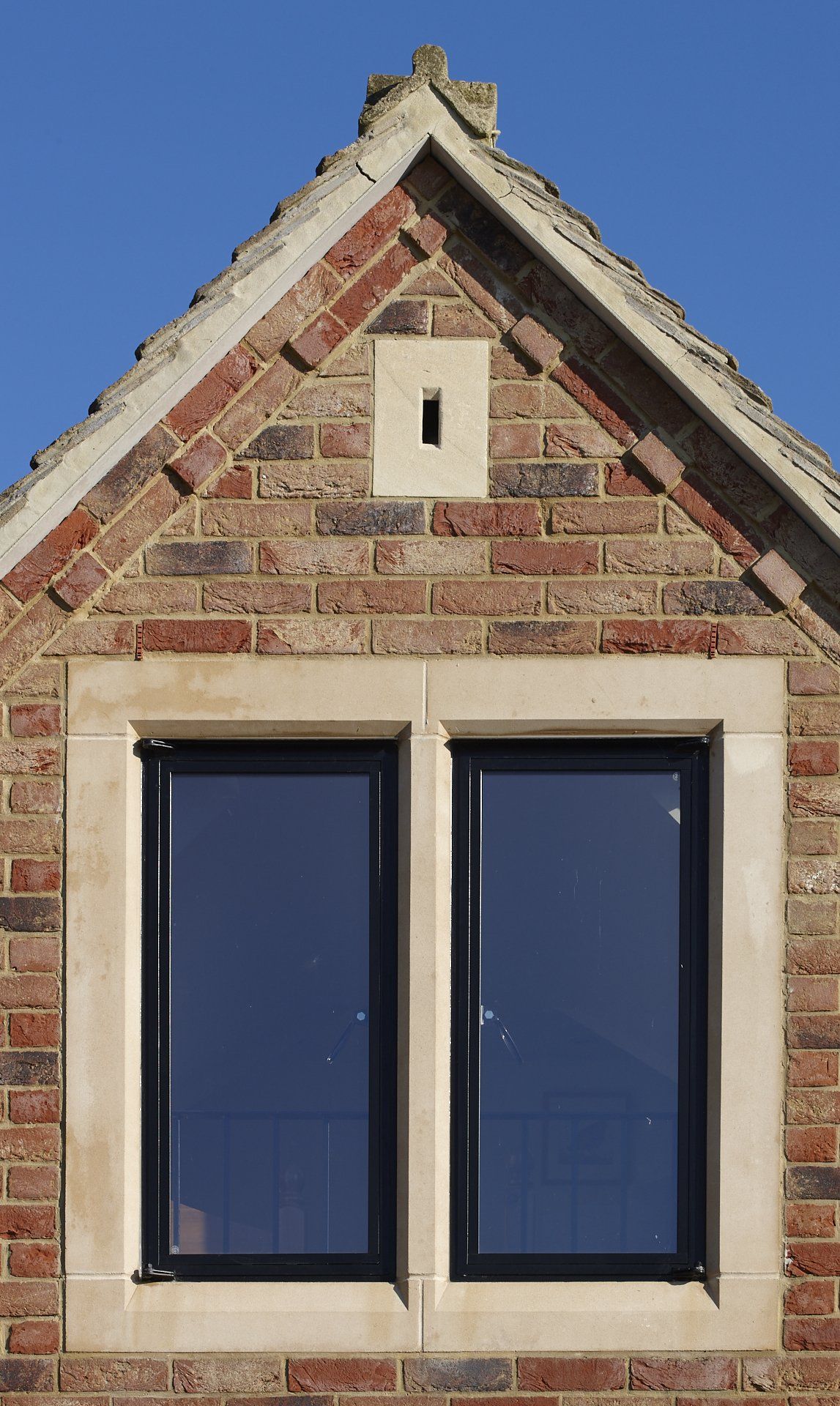 A brick building with two windows and a hole in the roof.