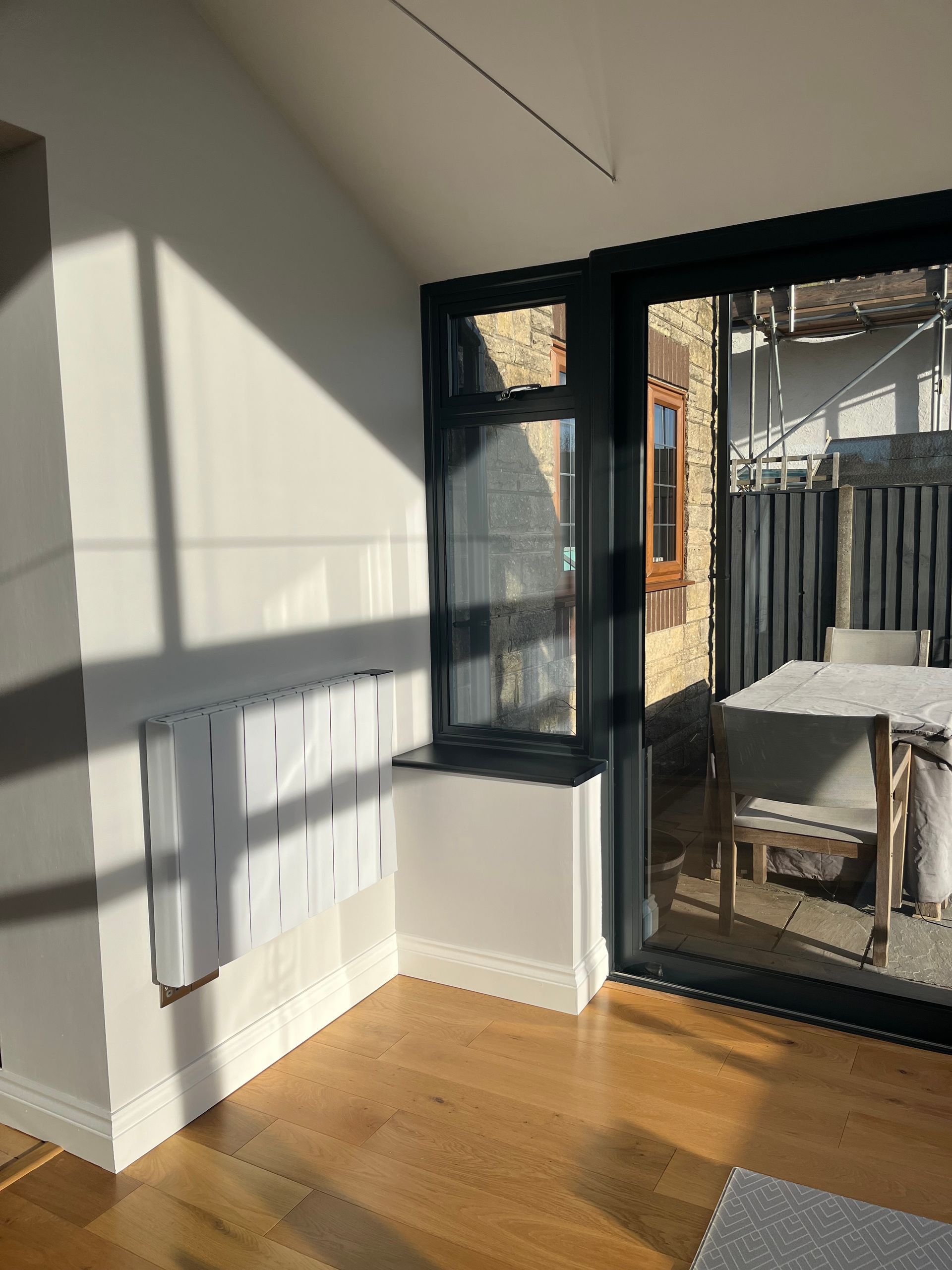 A living room with a table and chairs and a sliding glass door.