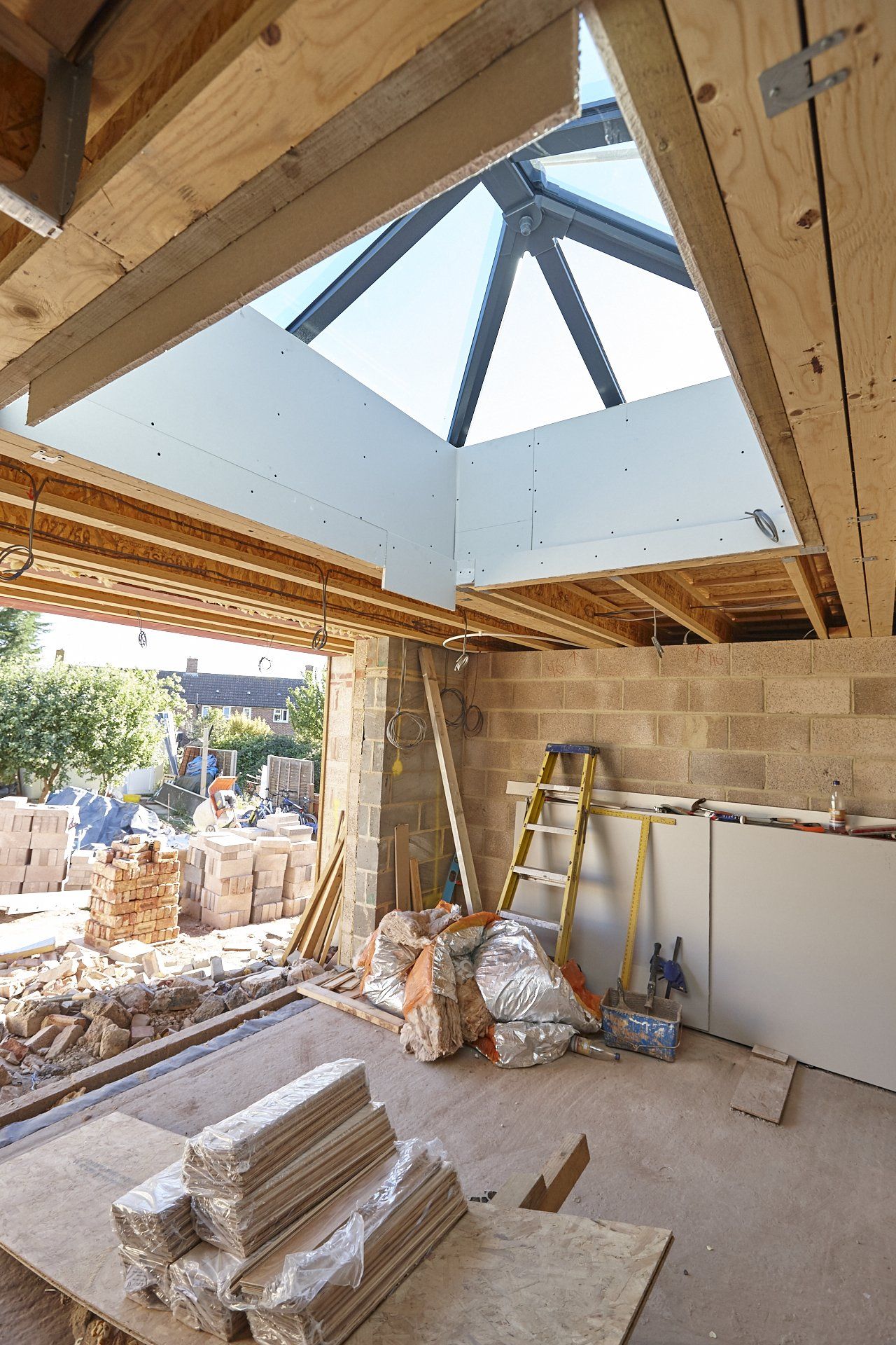 A room under construction with a skylight in the ceiling.