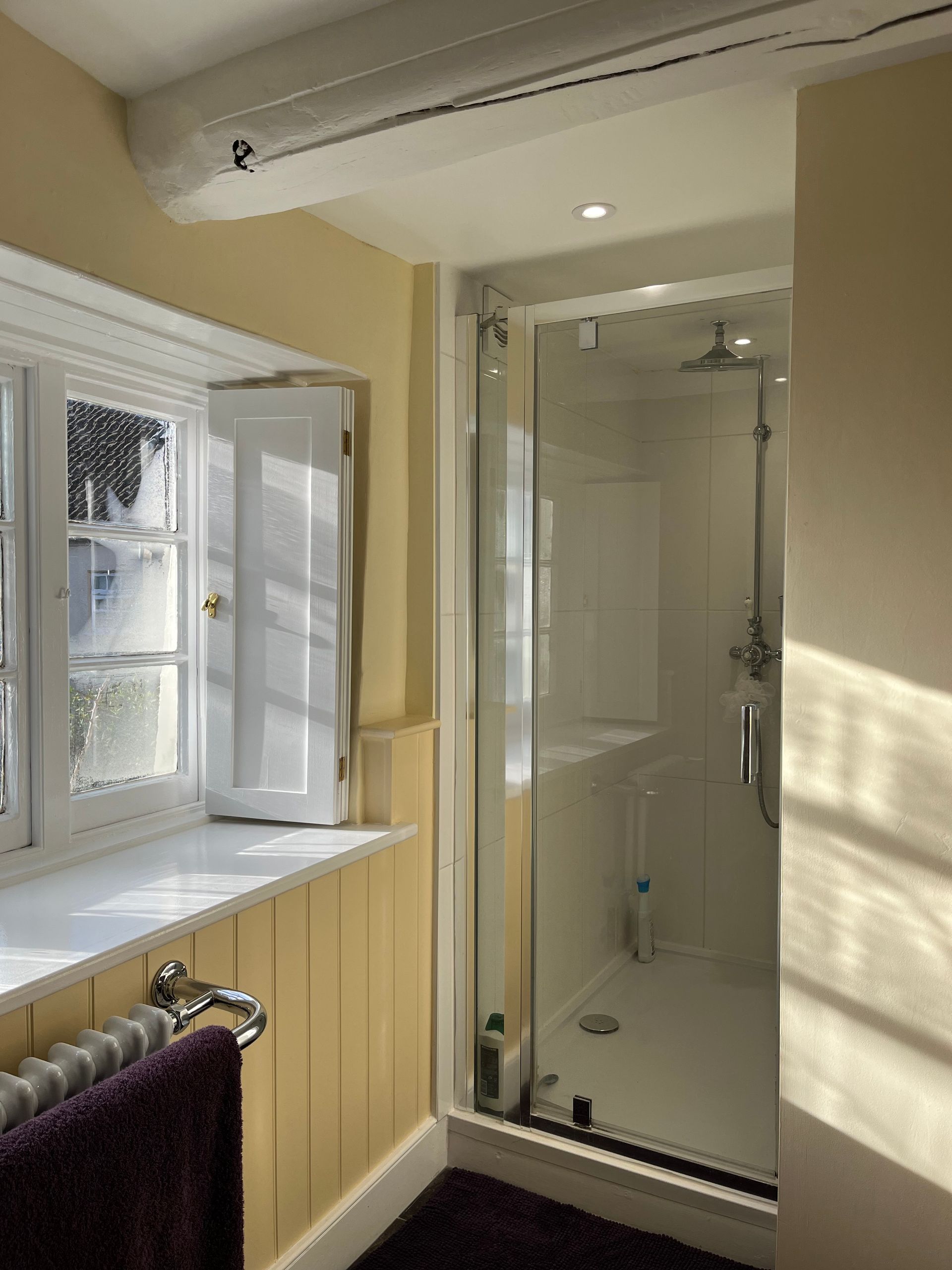 A bathroom with a walk in shower and a window