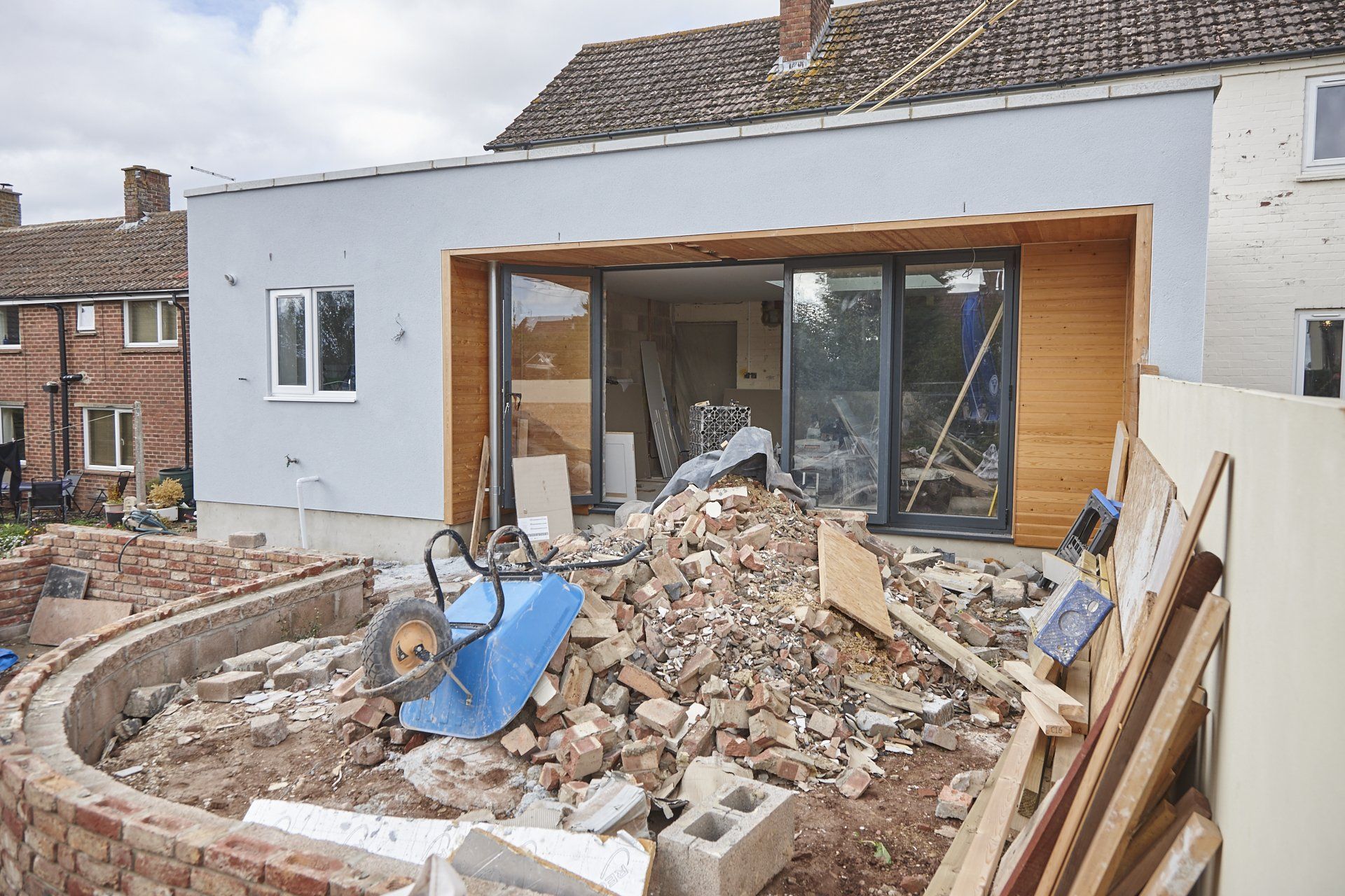 A house under construction with a pile of bricks in front of it.