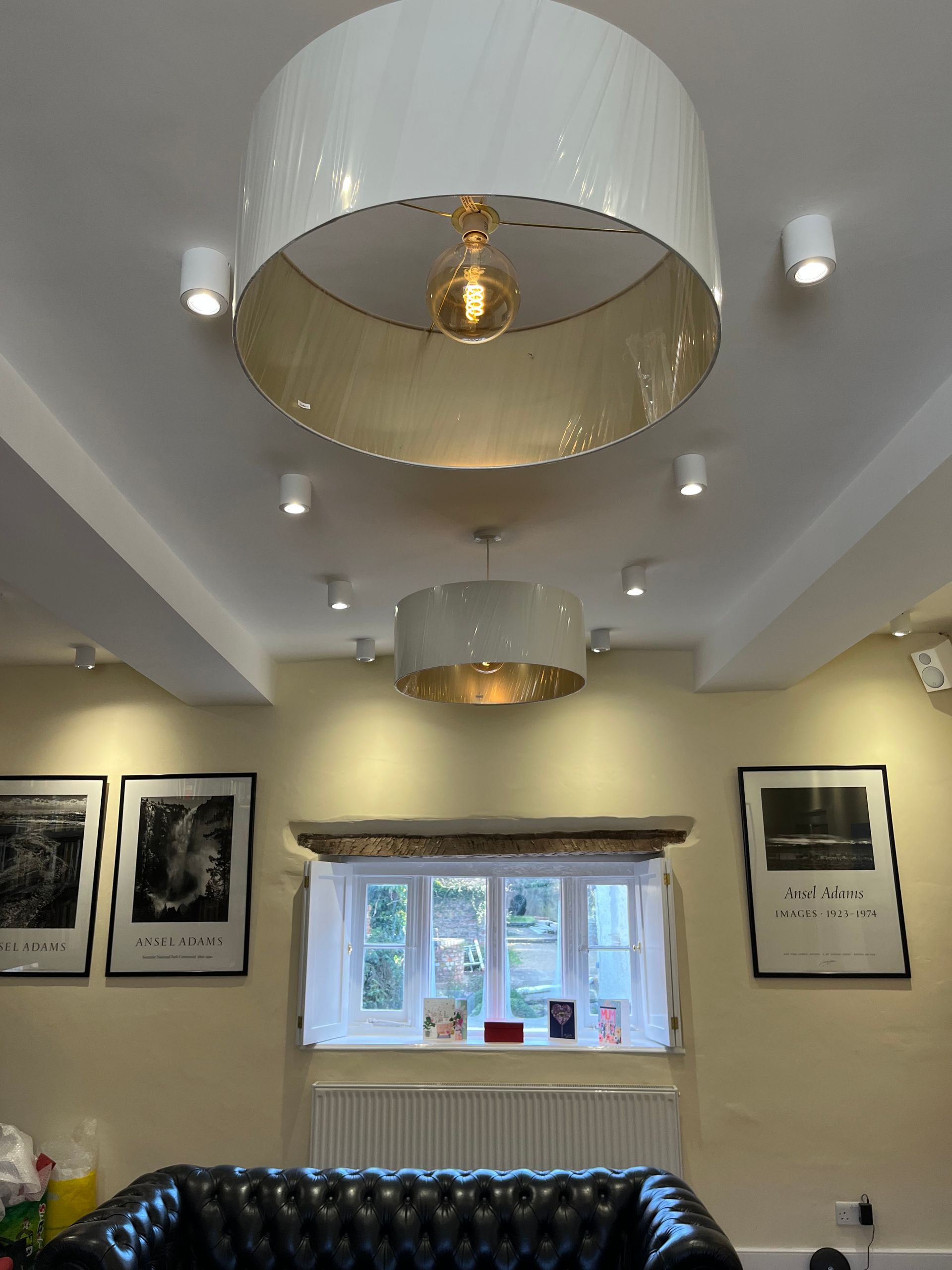 A living room with a couch and a lamp hanging from the ceiling