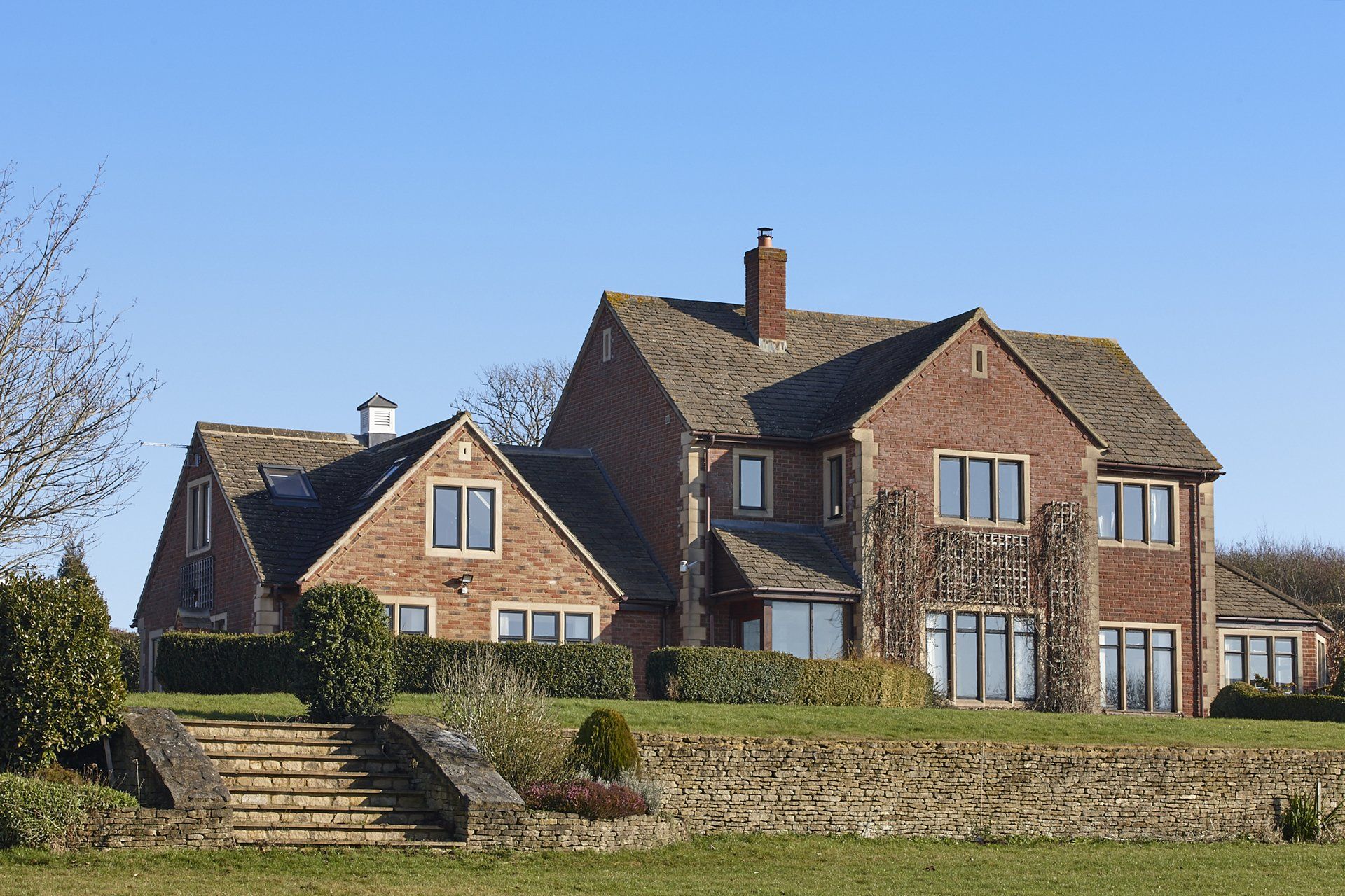 A large brick house with stairs leading up to it