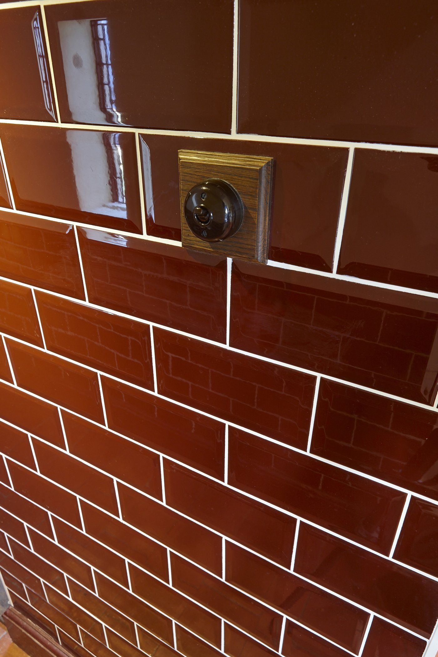 A brown brick wall with a light switch on it