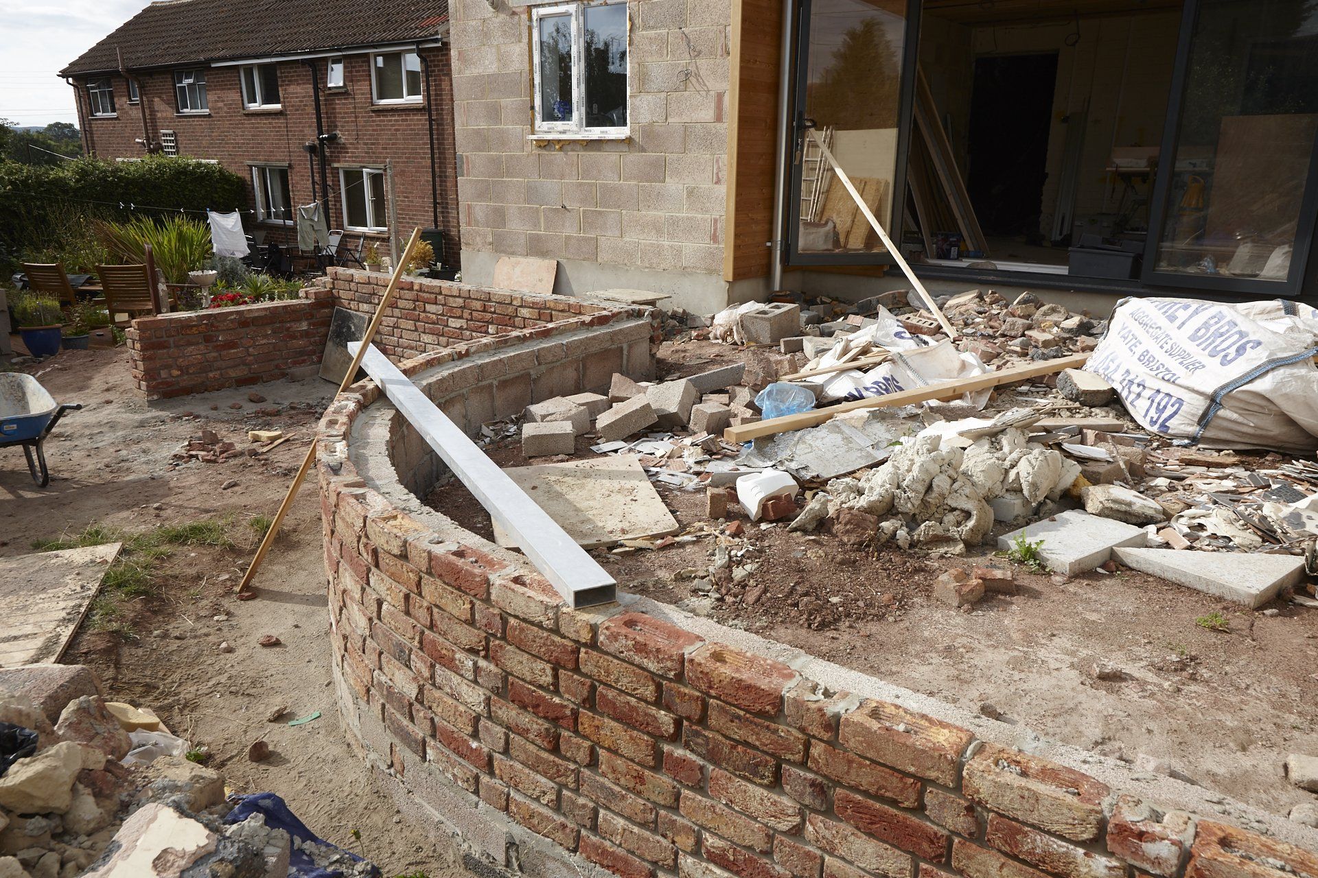 A brick wall is being built in front of a house.