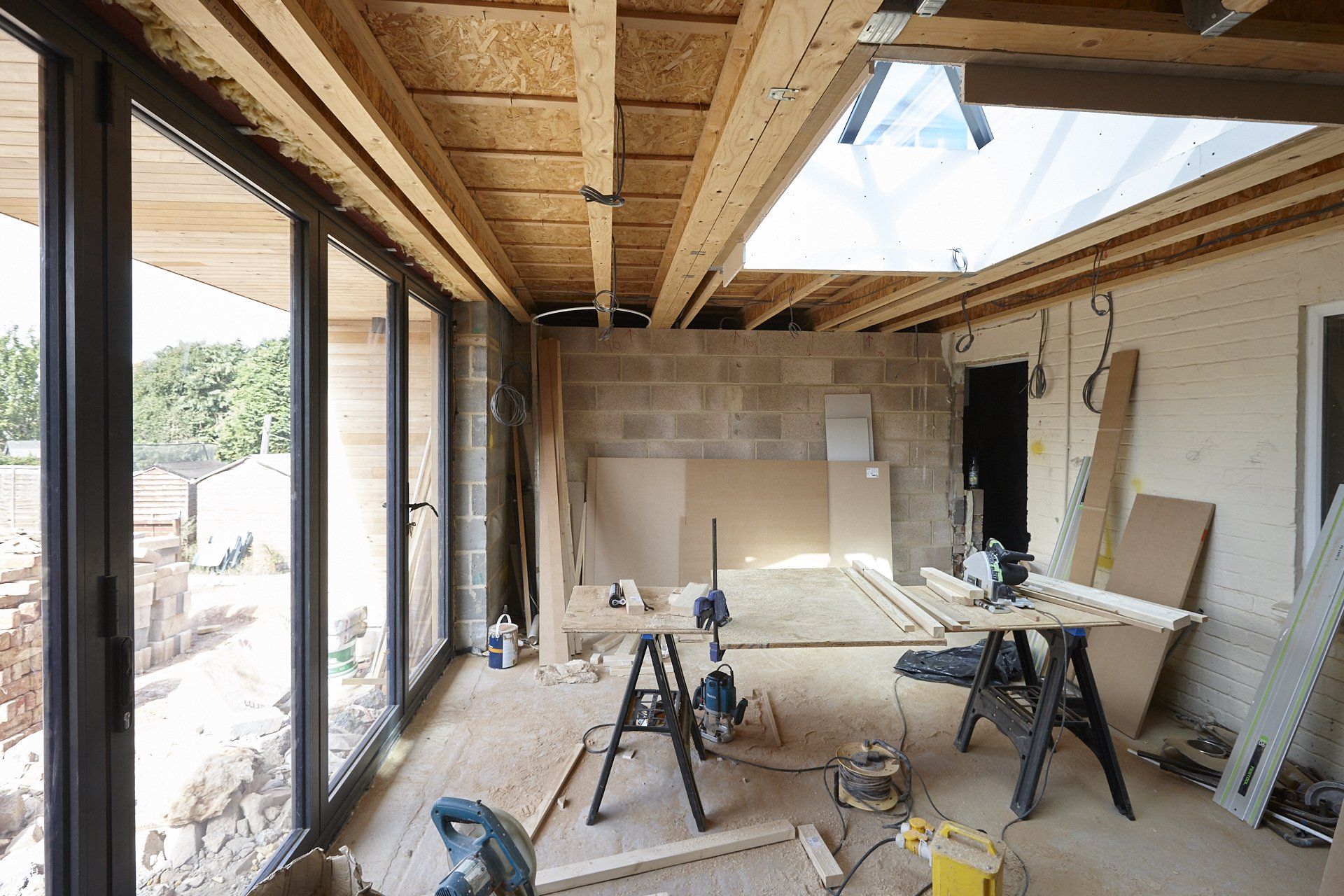 A room with a lot of windows and a table with a circular saw on it.