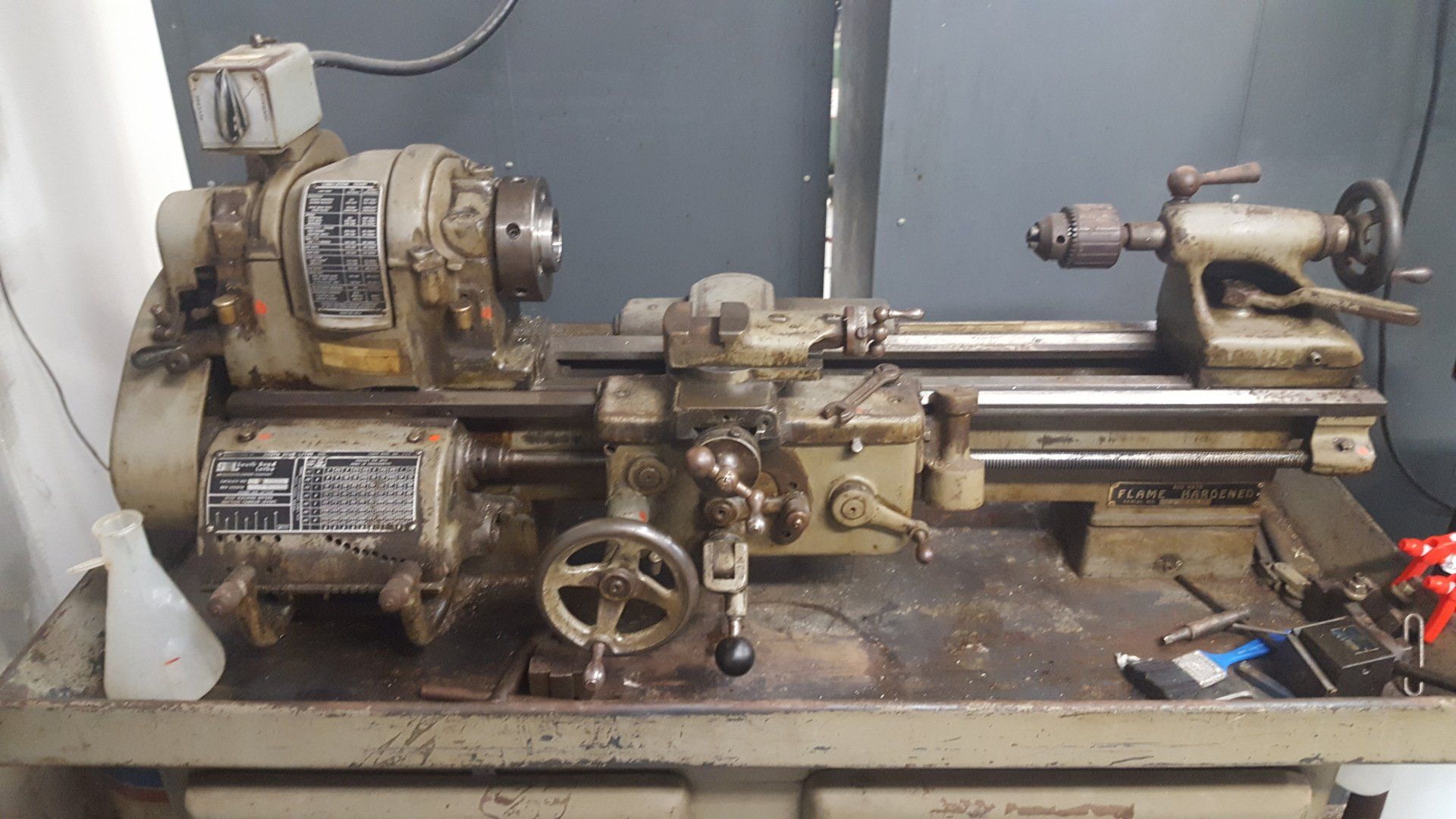 A lathe with a motor attached to it is sitting on a table.