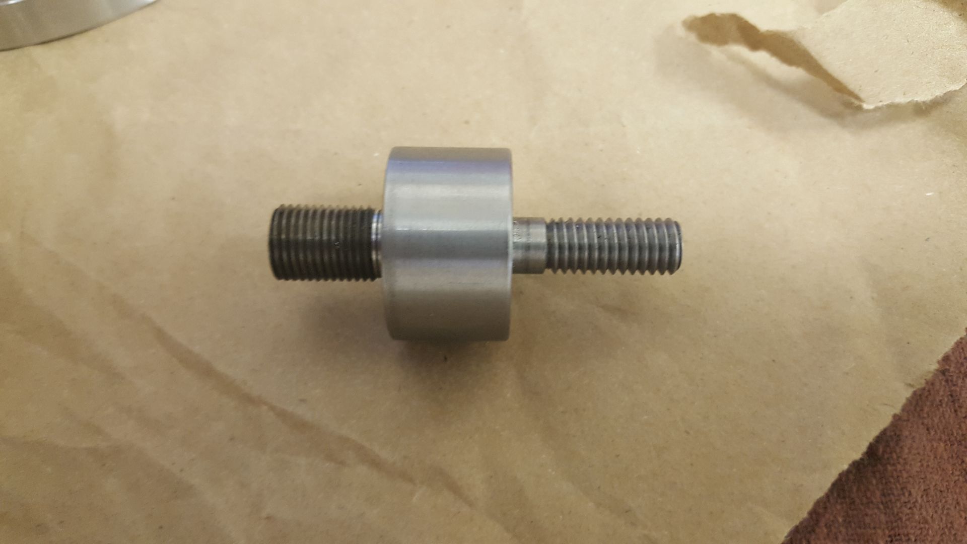 A metal object is sitting on top of a piece of brown paper.