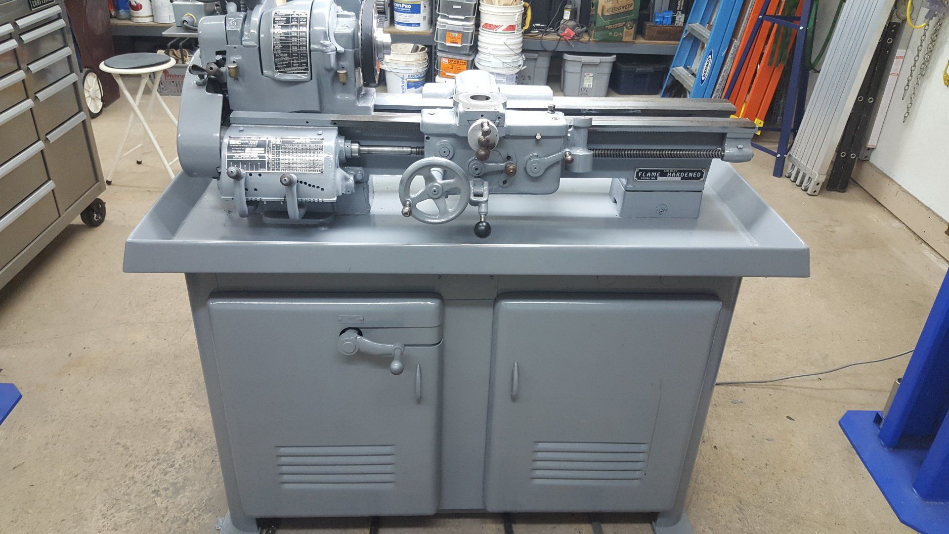 A lathe is sitting on a table in a garage