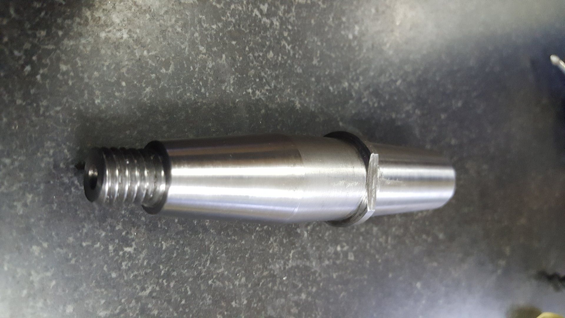 A close up of a metal shaft on a table.