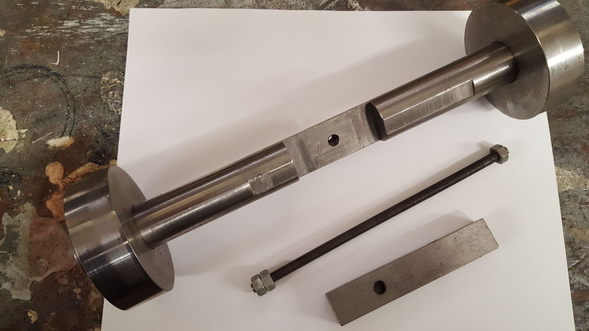 A piece of metal is sitting on top of a piece of paper.