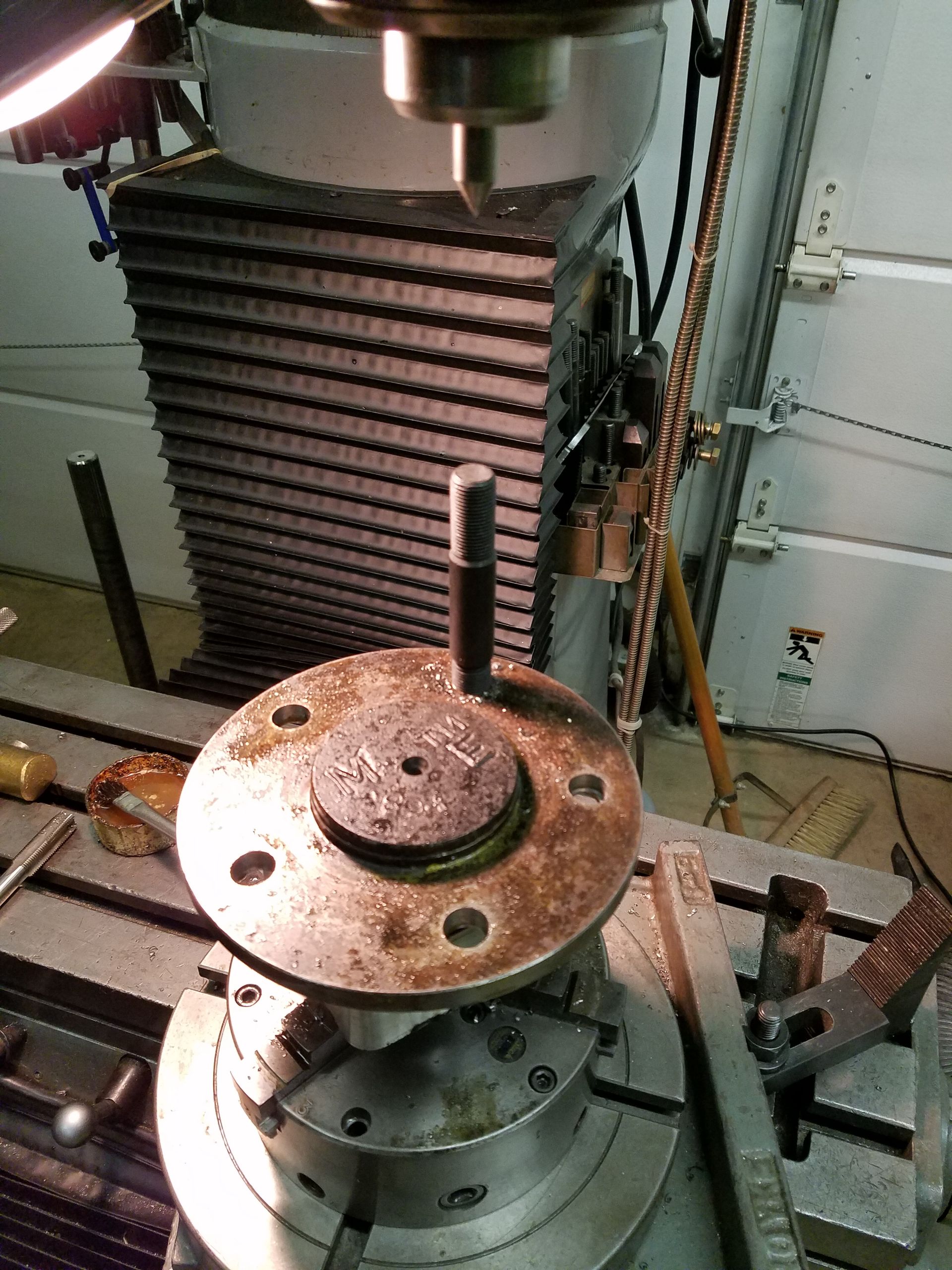A machine is cutting a piece of metal on a lathe.