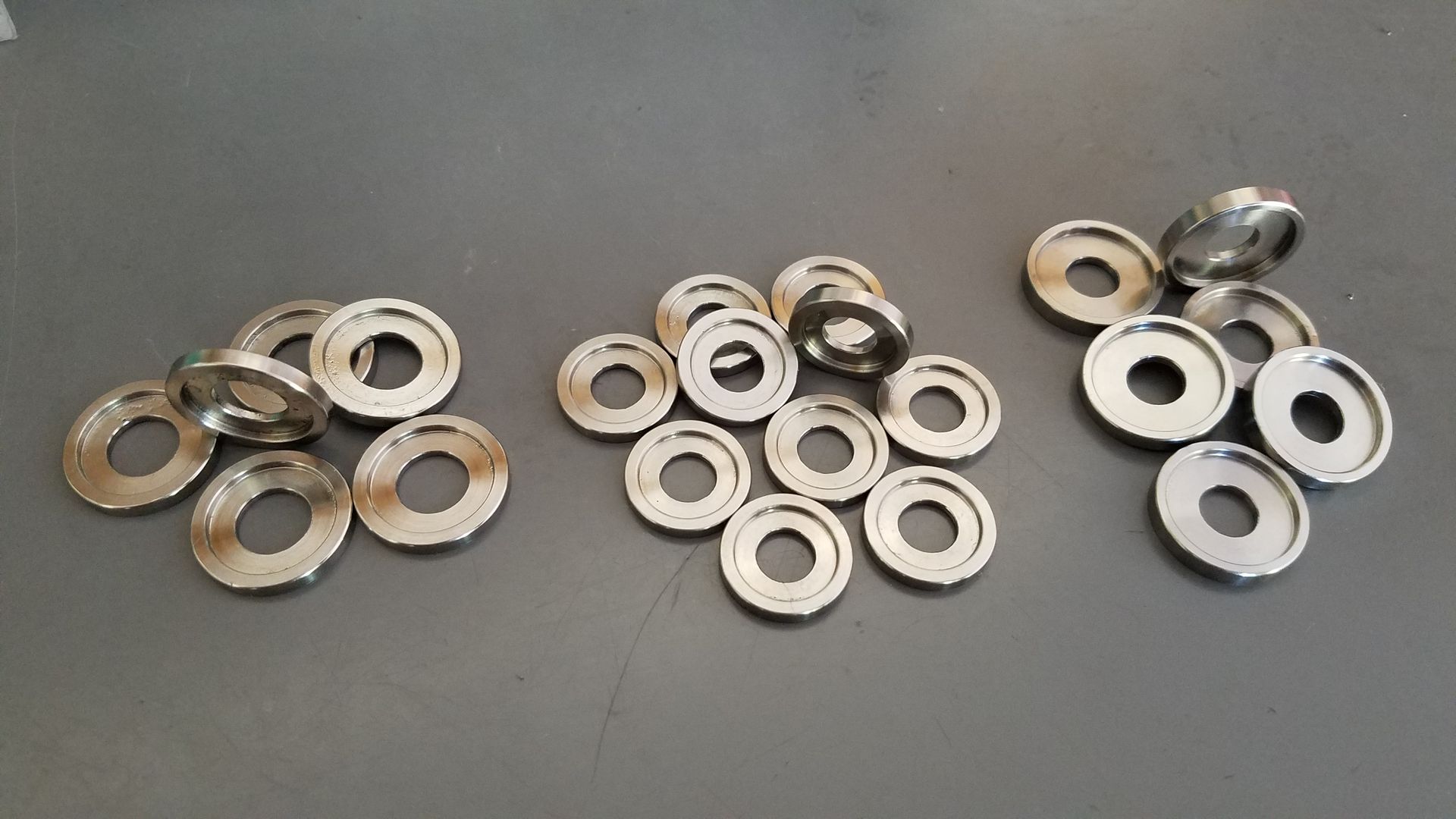 A bunch of metal washers are stacked on top of each other on a table.