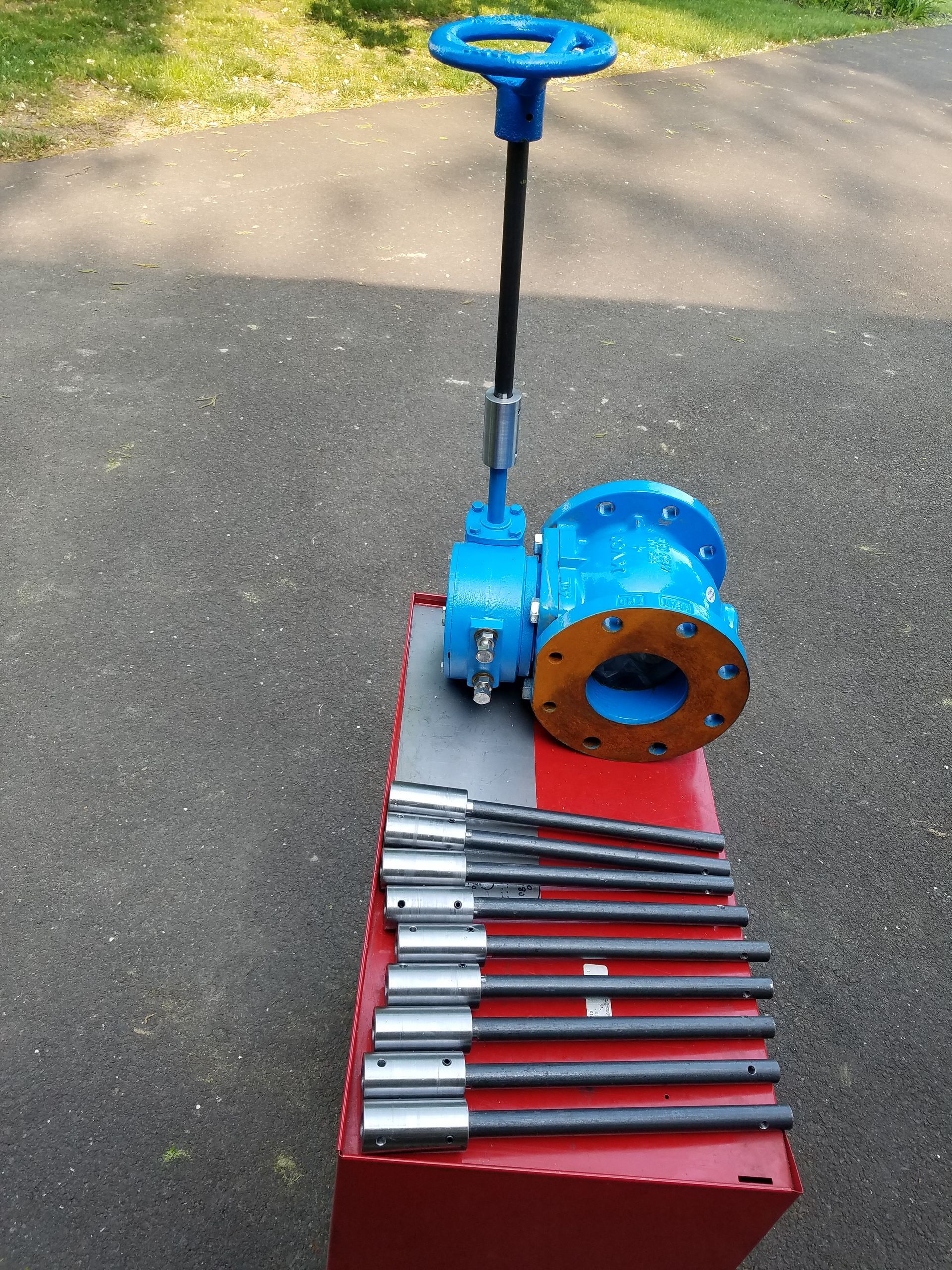 A blue valve is sitting on top of a box of tools
