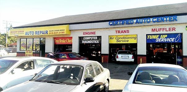 A lot of cars are parked in front of an auto repair shop