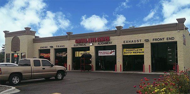 A lot of cars are parked in front of a car repair shop.