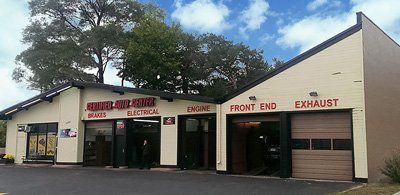 A garage with two garage doors and a sign that says front end exhaust