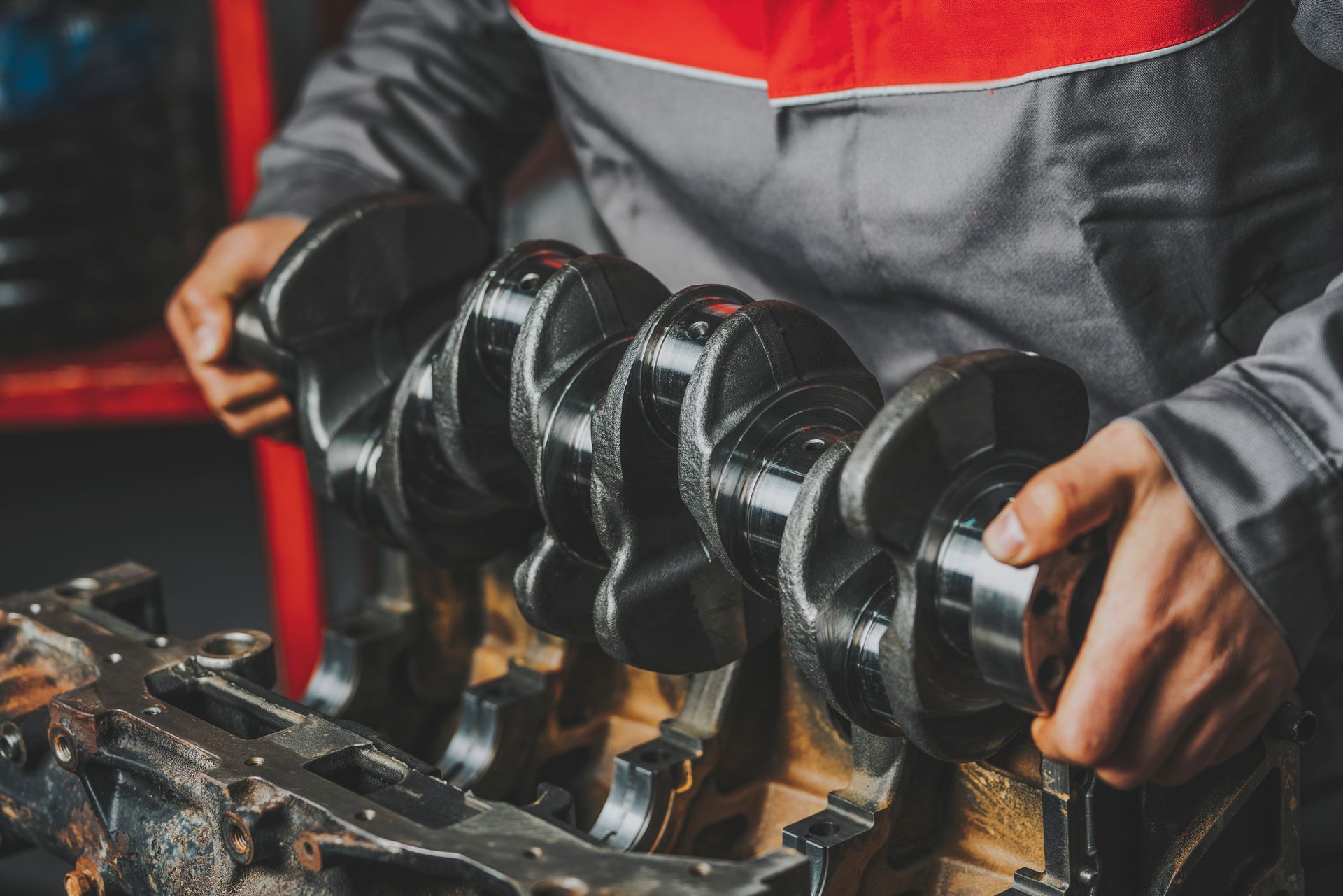A man is working on a car engine in a garage.