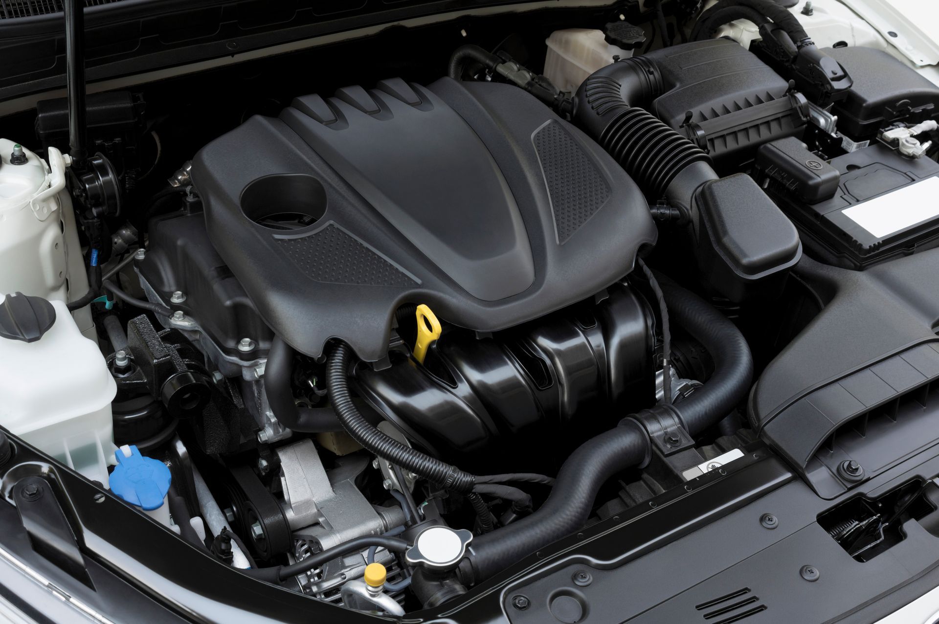 A close up of a car engine with the hood open