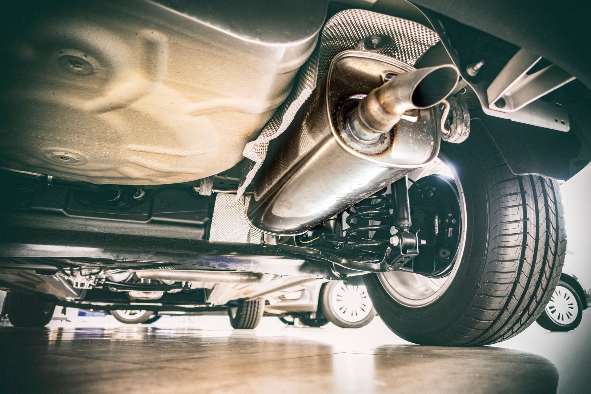 A close up of the underside of a car with a exhaust pipe.