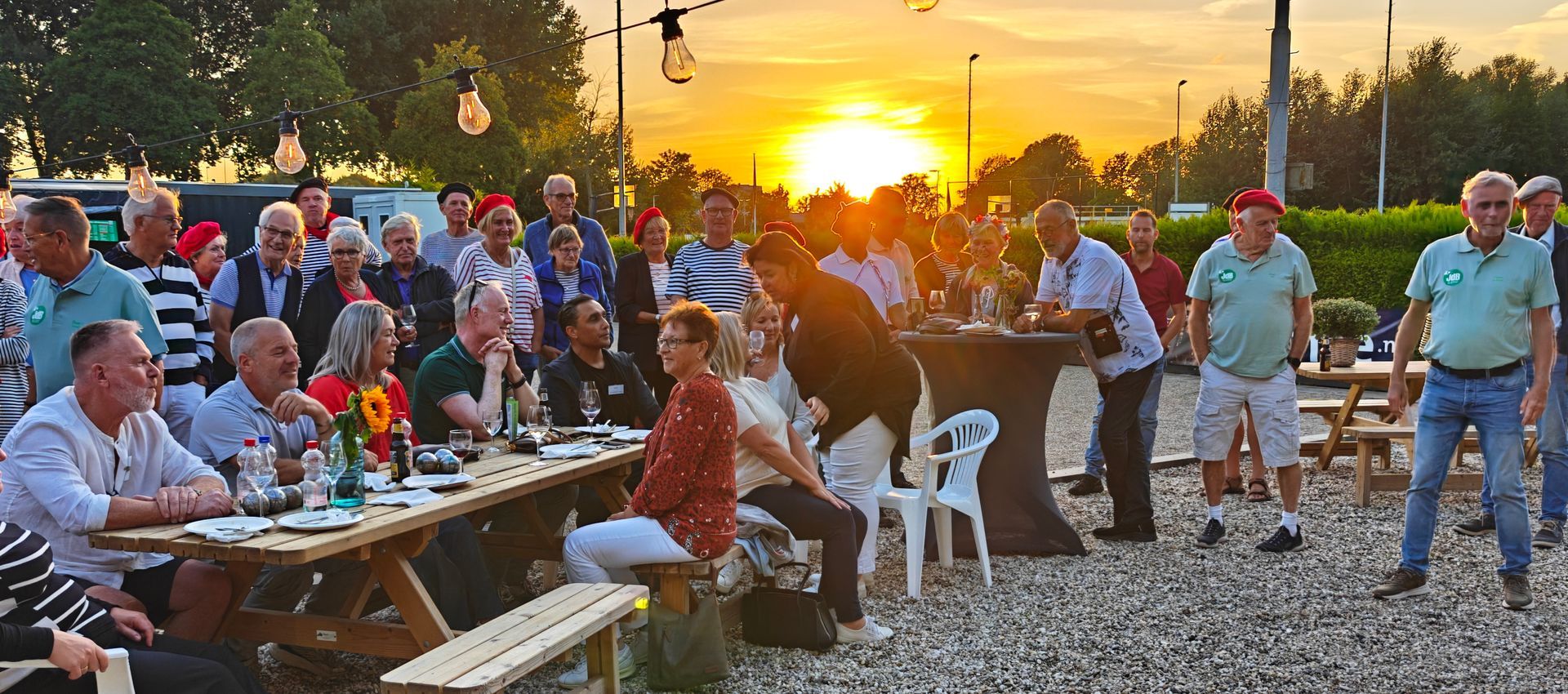 Wat een heerlijke avond hebben we gehad! Afgelopen zaterdag stond onze Jeu de Boules-baan helemaal in het teken van de Franse Avond. Al vanaf 16.15 uur druppelden de gasten en sponsoren binnen, en de sfeer zat er meteen goed in.
Na de voorbereidingen, al vanaf 9 uur ’s morgens, trapte voorzitter Gerda de avond af met een warm en vrolijk welkom, onder het genot van een lekkere champagne van sponsor Olaf van de Ridder Wijn en Bieren, Zij benadrukte hoe blij we zijn met al onze sponsoren – zonder hun steun en de Club van 100 zouden plannen voor een kantine niet eens mogelijk zijn. Extra dank ging uit naar Rob en Peter, die met veel enthousiasme de sponsoren hebben benaderd, en natuurlijk ook naar Floris, Loes en Piet voor al de vele uren het werk achter de schermen.