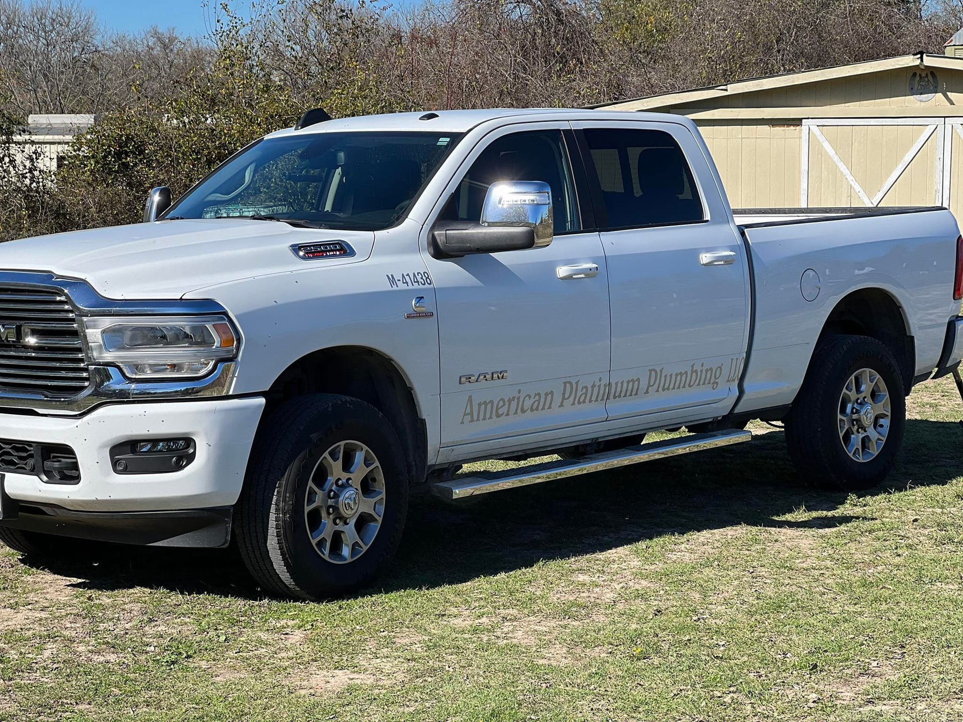 A white dodge ram truck is parked in a grassy field.